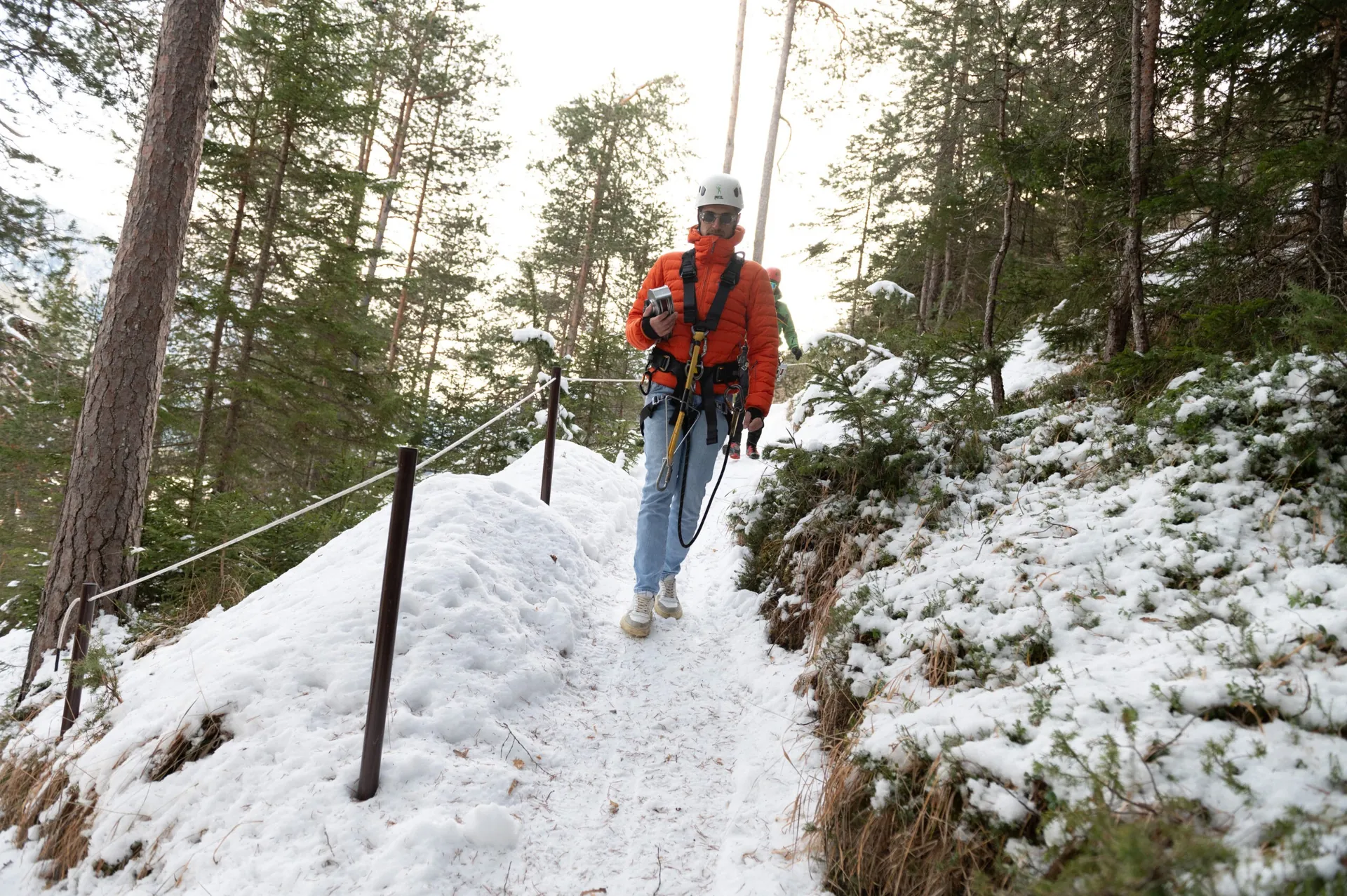 Camminata sul sentiero innevato con imbracatura da zipline