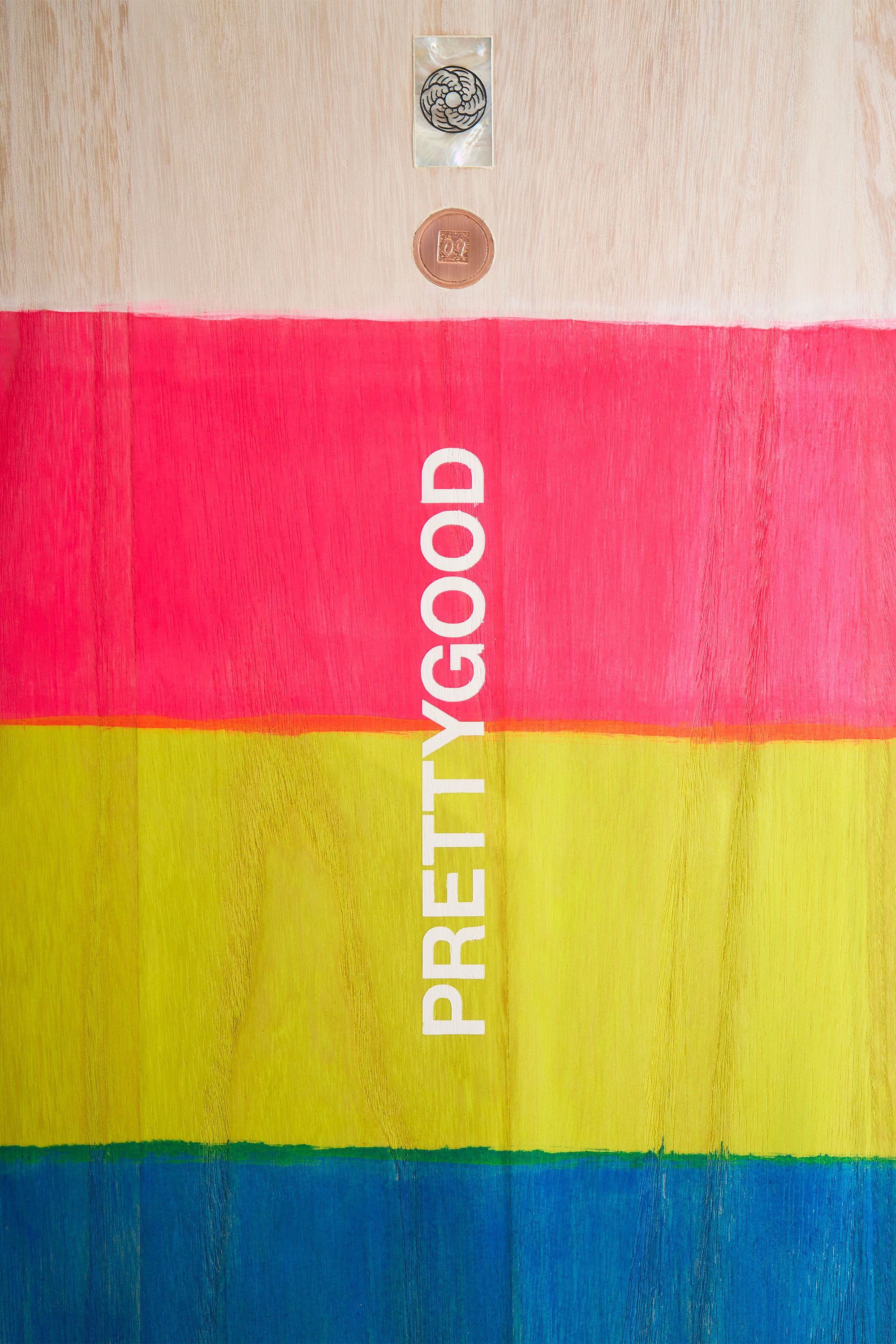 Hand painted logo on a wooden surfboard