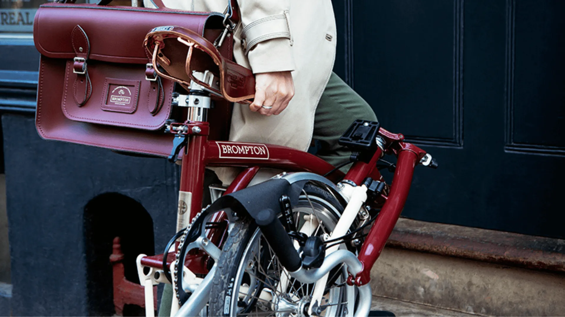 A folded Brompton bike being carried into a building