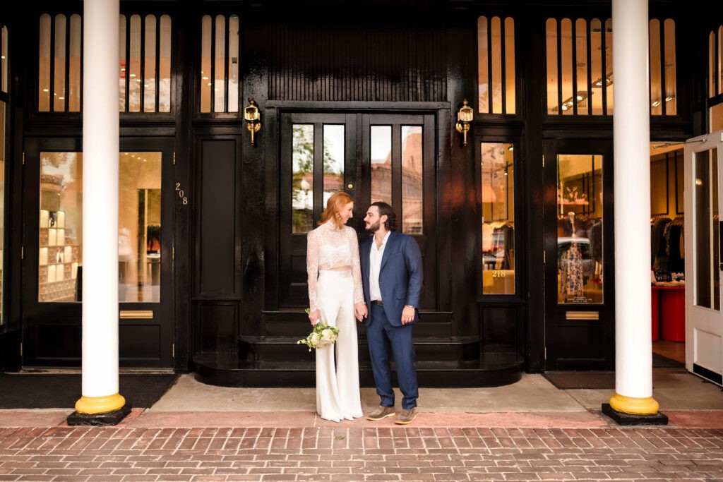 Bride and groom standing in front of their wedding venue in downtown Colorado.