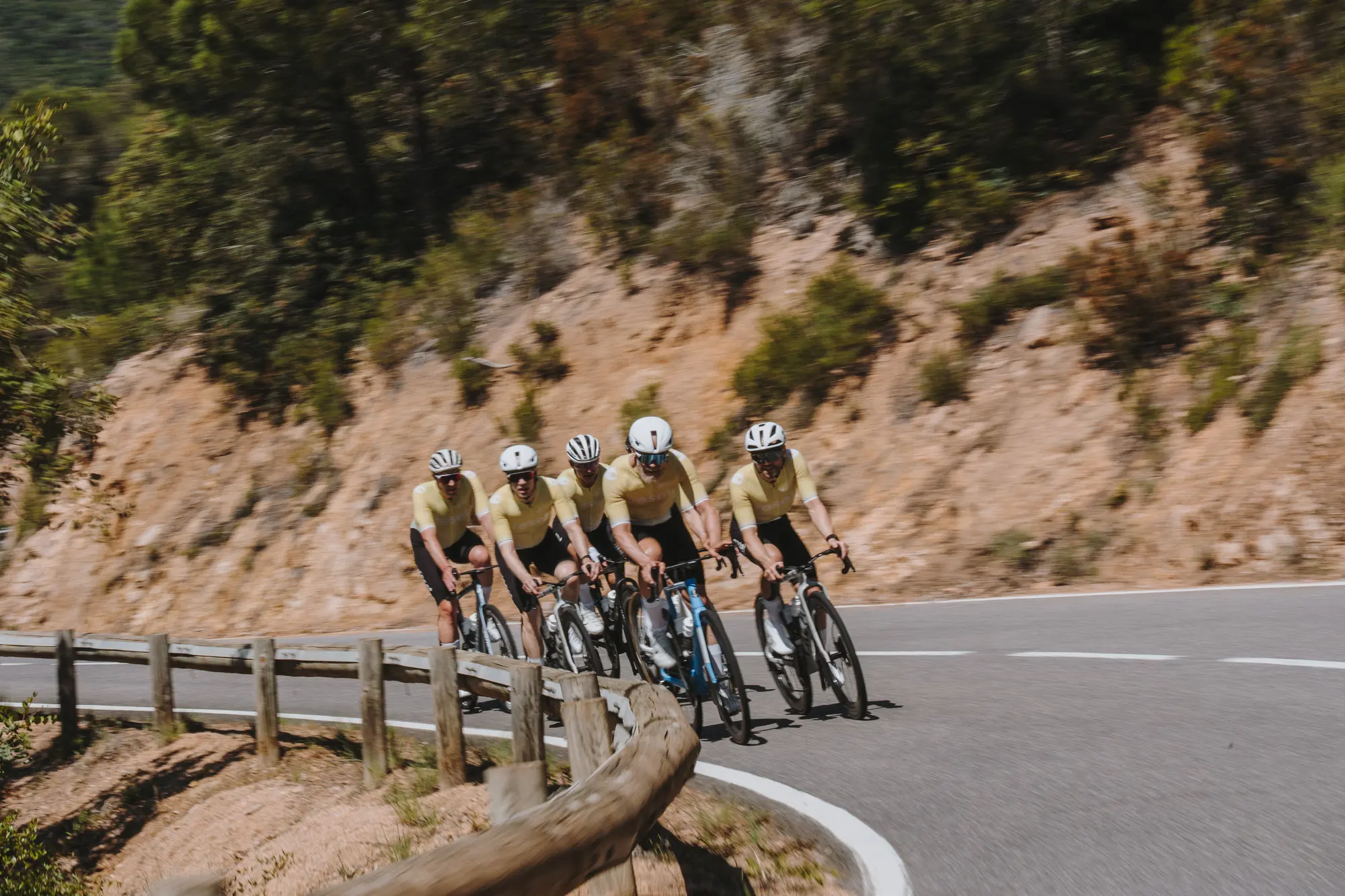 The reset cc team riding a hairpin on the Girona coast