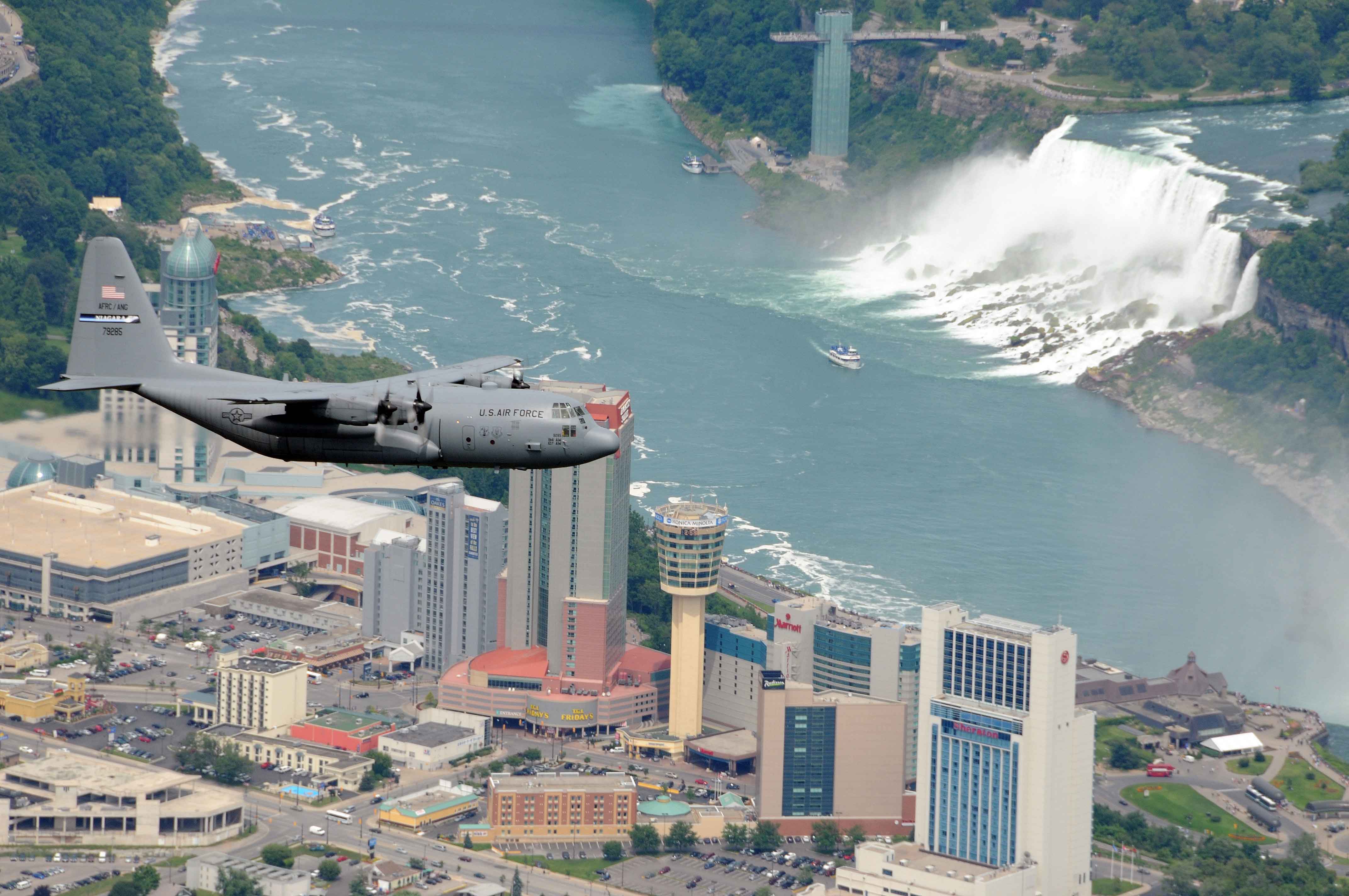 U.S. Air Force C-130 aircraft in flight over Niagara Falls and the surrounding cityscape at Niagara Falls Air Reserve Station, New York