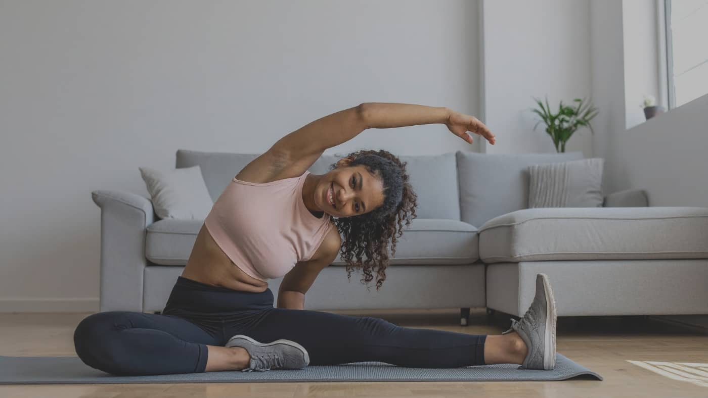 Jeune maman faisant des étirements doux pour sa reprise du sport après l'accouchement.