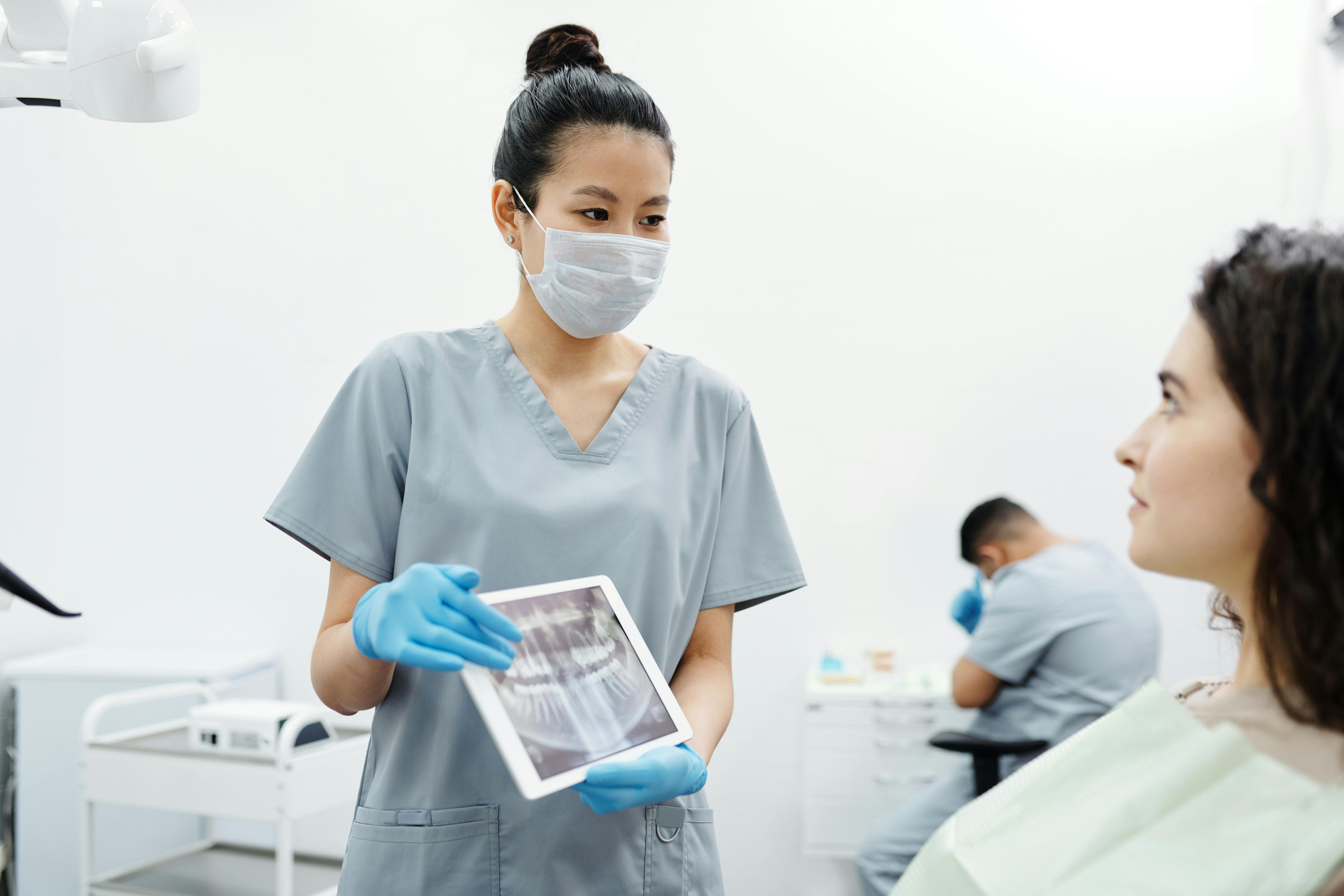 Dental hygienist showing patient xrays on a tablet