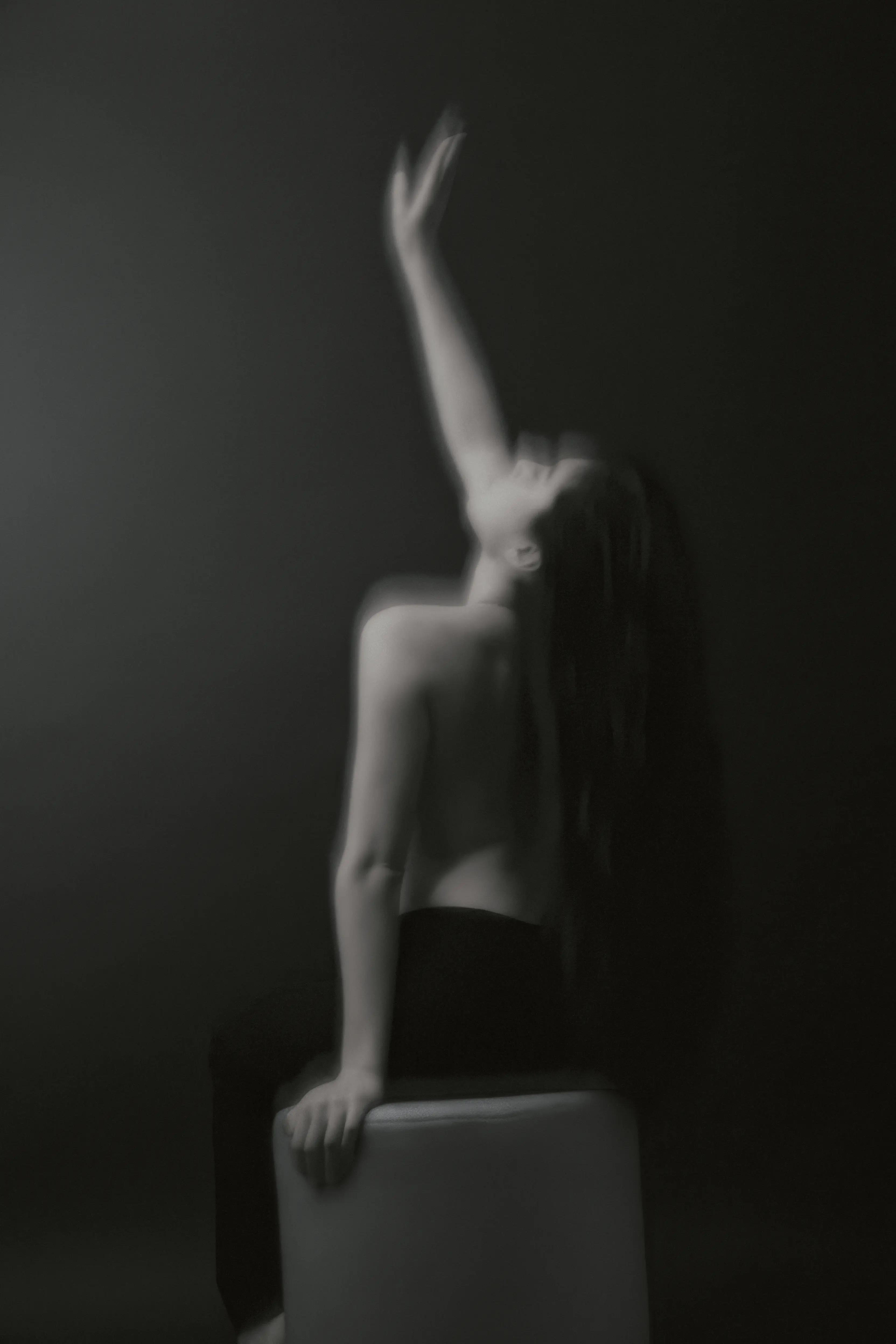 Künstlerisches Schwarzweiß Portrait im Fotostudio Frankfurt mit gestrecktem Arm und atmosphärischem Licht und Motion Blur