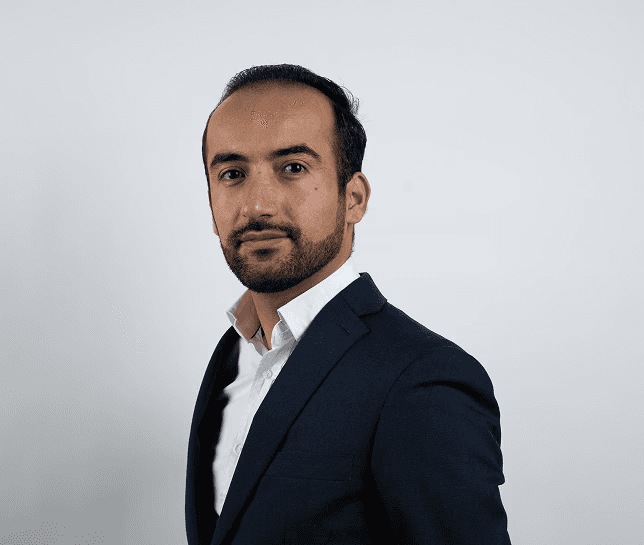 Foto van Niwar, eigenaar van vsocheque.nl. Man in pak die de camera in kijkt.