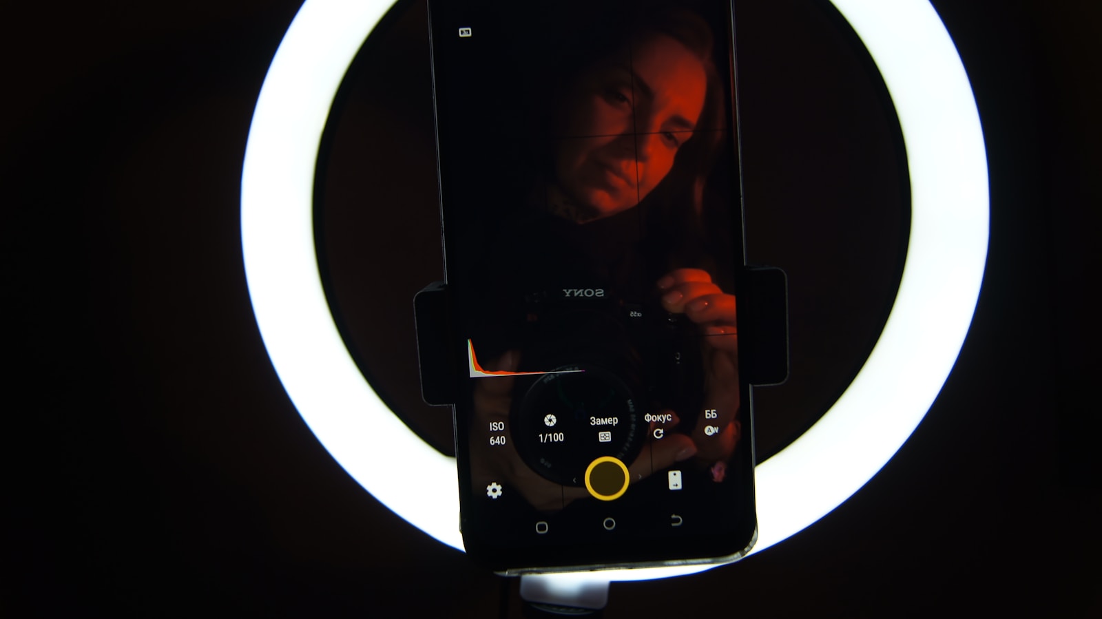 A phone mounted in front of a ring light, set up to record a video