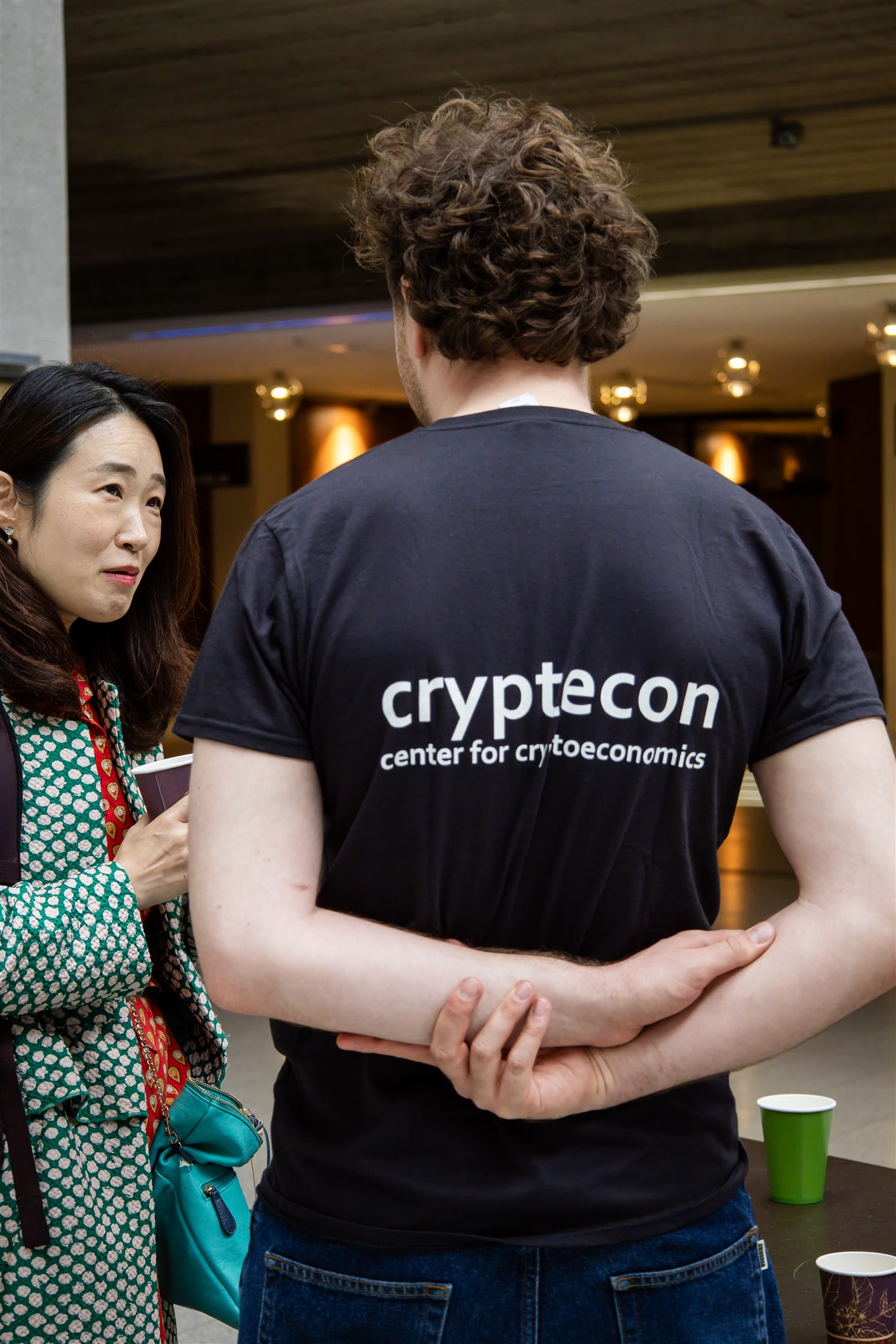 Attendees interacting during EthereumZüri networking event with cryptoecon branding