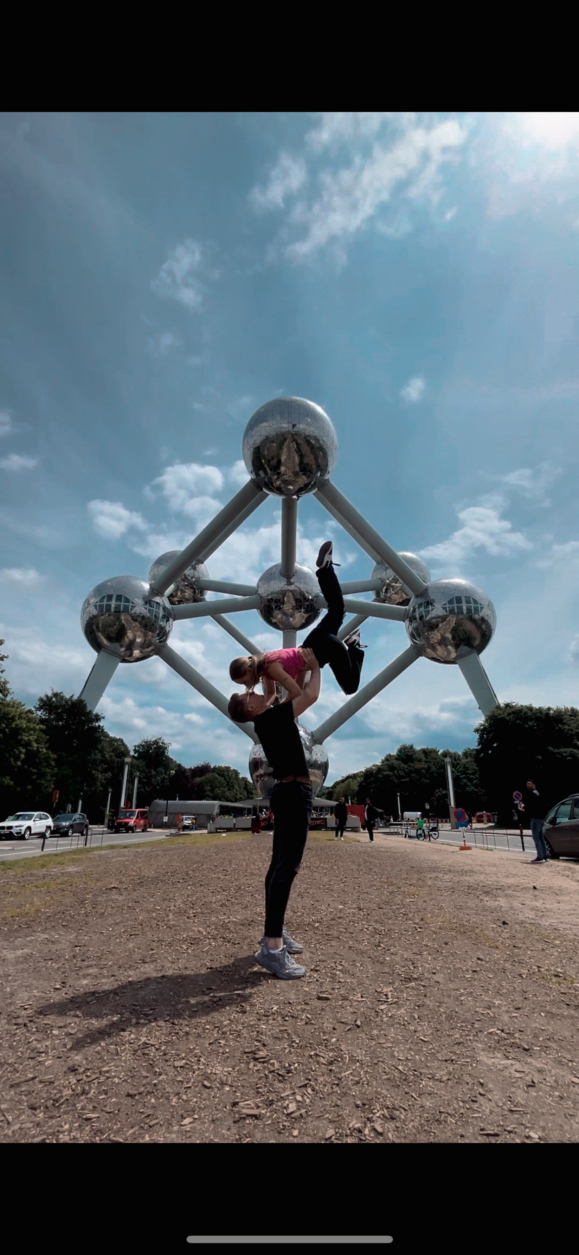 A bride and groom share a kiss, enveloped in the bride's flowing veil. The soft focus and gentle light convey a romantic, intimate atmosphere.