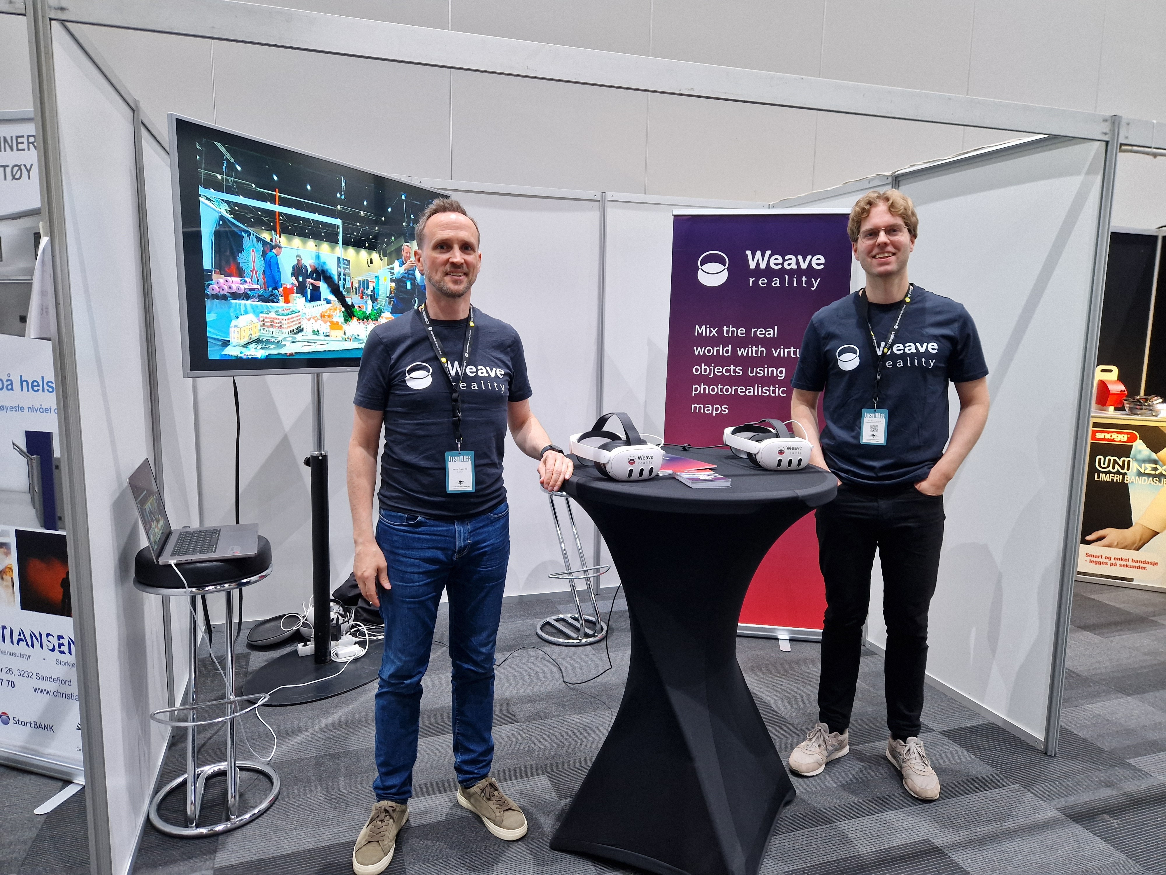 Two employees from Weave Reality staning at the stand, smiling to the camera