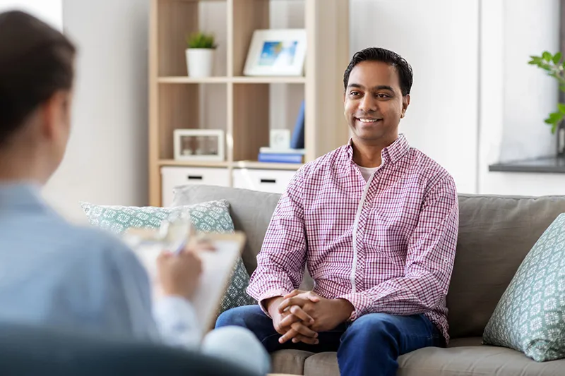 Adult therapy appointment with a therapist and client talking in a calm office setting in Dallas
