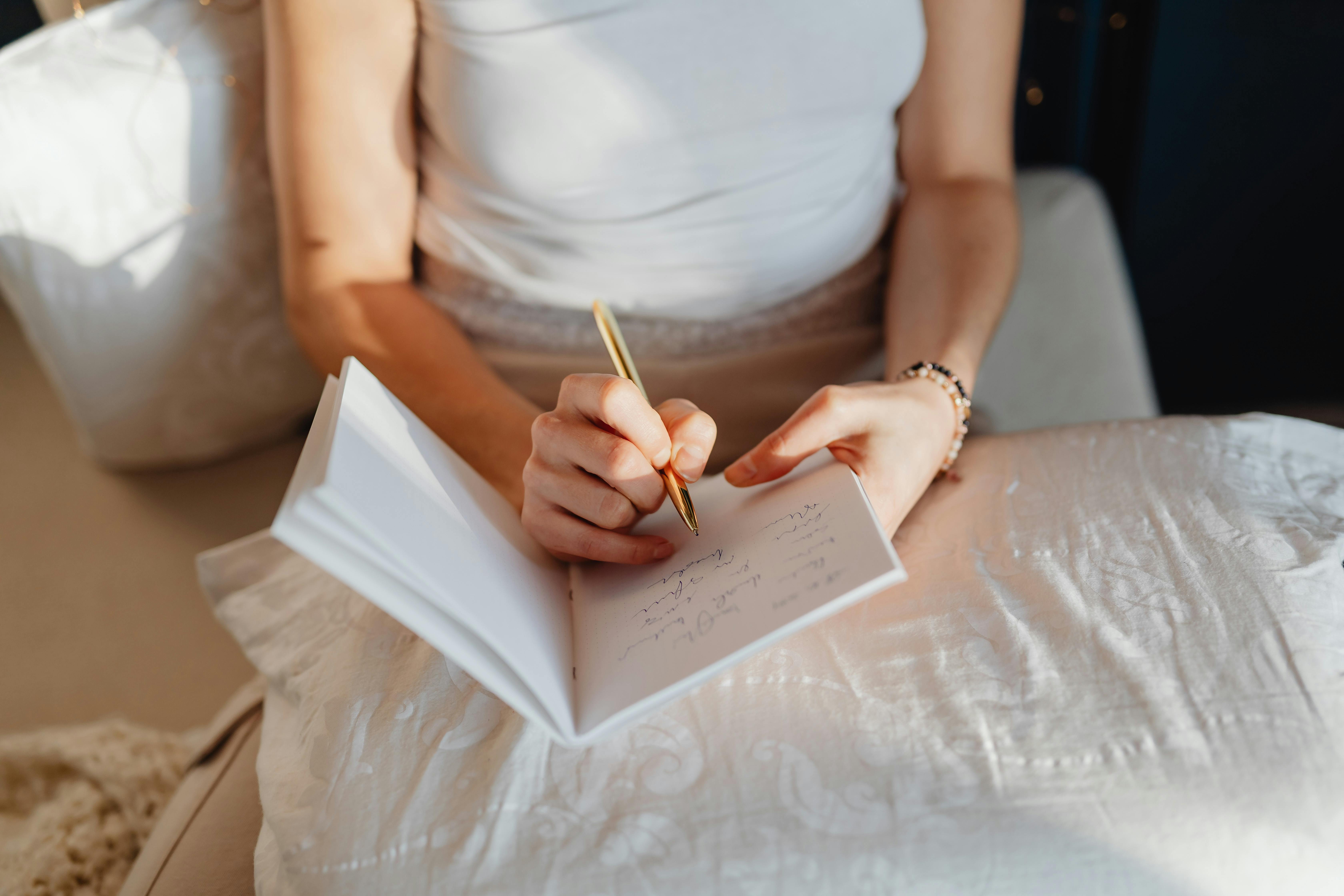 Person sits in bed journaling.