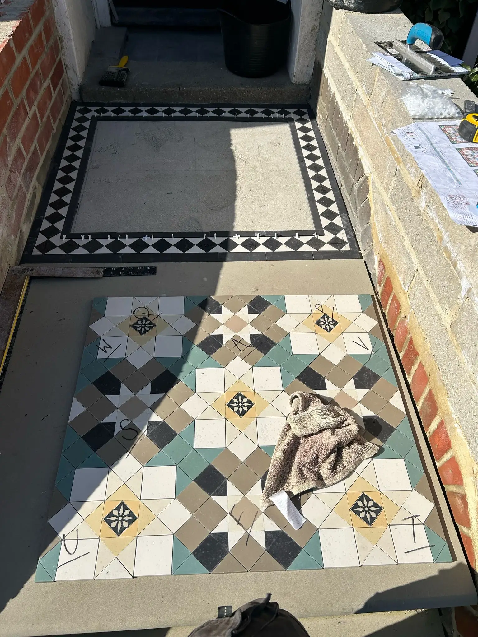 Aerial view of a patio featuring geometric tiles, sun umbrellas, and a well-decorated outdoor setting.