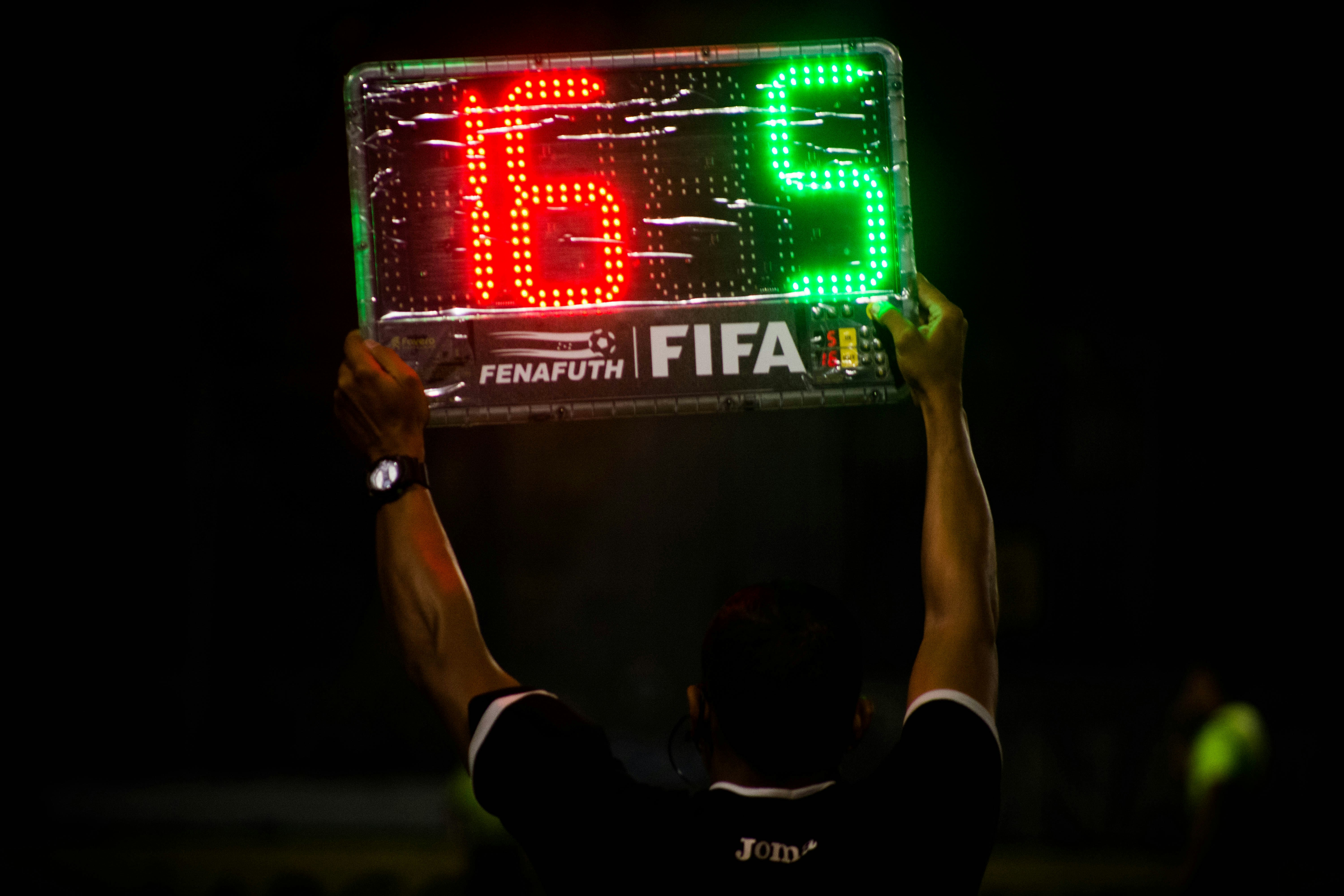 Man holding FIFA soccer game scoreboard