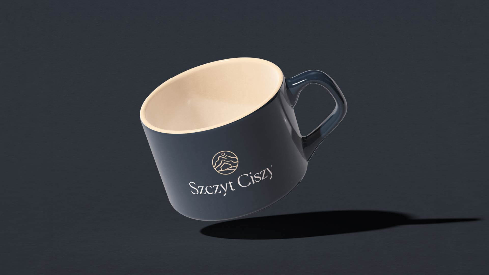 Granatowy kubek z logo Szczyt Ciszy na ciemnym tle.