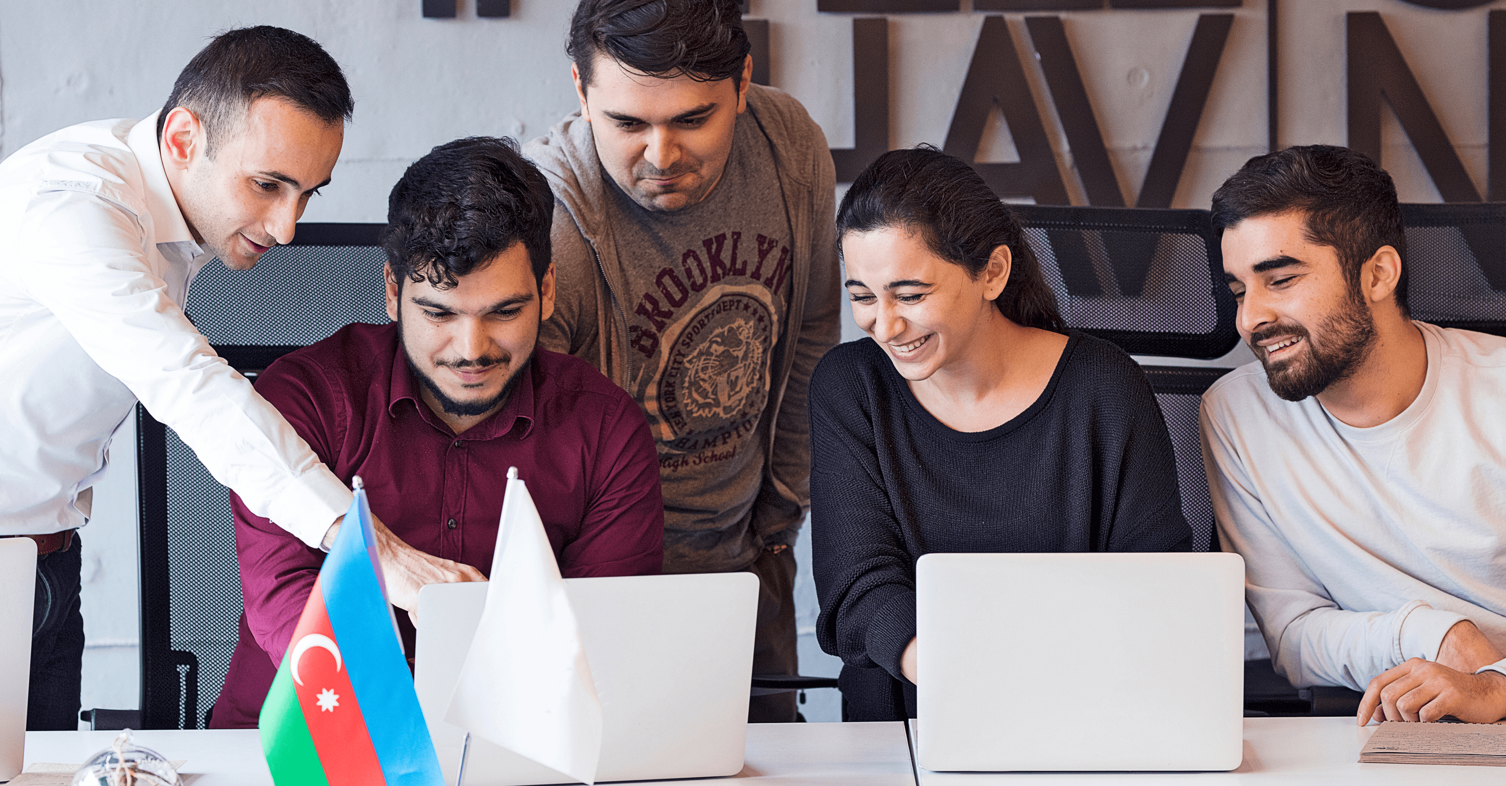 Three people sitting on a couch in a room looking at mobile devices