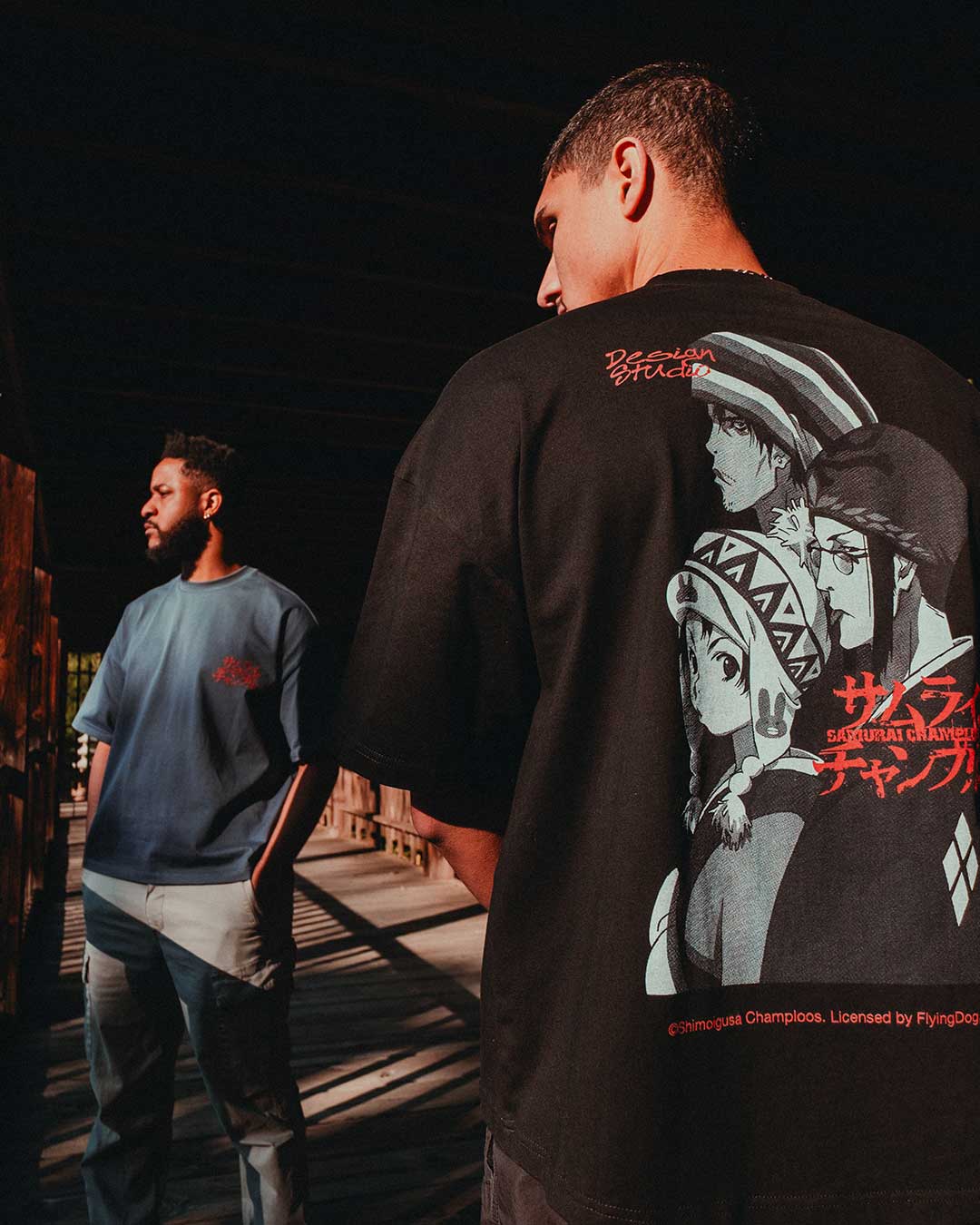 Young person with curly hair wearing blue clothing, smiling at camera