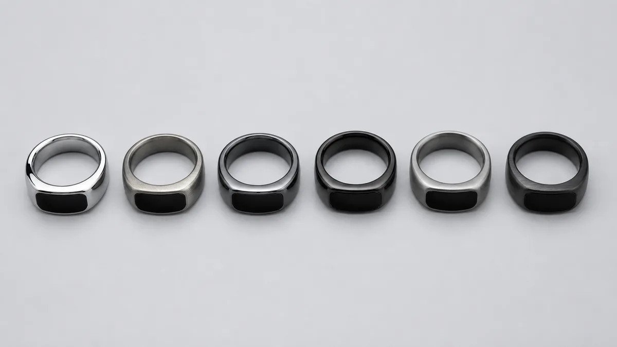 Top-down row of smart tasbih rings in different metal finishes on a neutral studio surface