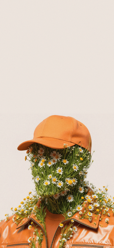 A surrealist digital artwork of a person wearing an orange baseball cap and a glossy orange leather jacket. Their entire face and neck are composed of thick green grass and numerous blooming white daisies with yellow centers, creating a floral humanoid appearance against a neutral beige background