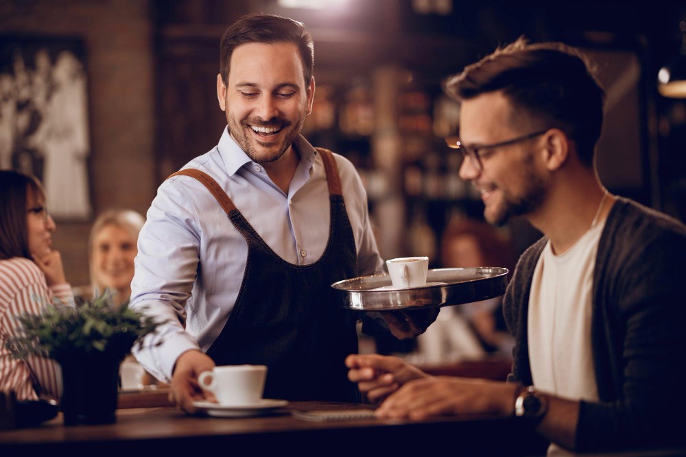 restaurant-waiter-serving-coffee-example-of-best-restaurant-booking-software-freepik