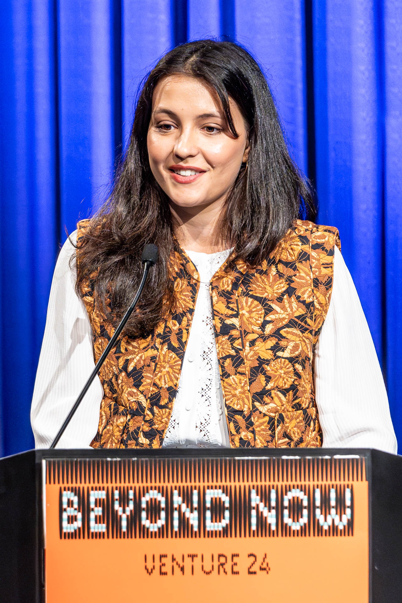 a student at a podium presenting a project in a Theatre