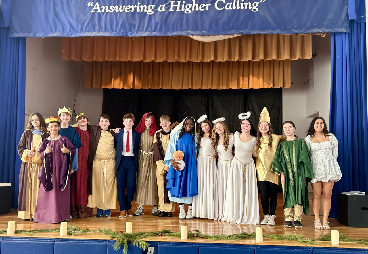 Students in Nativity costumes lined up on stage