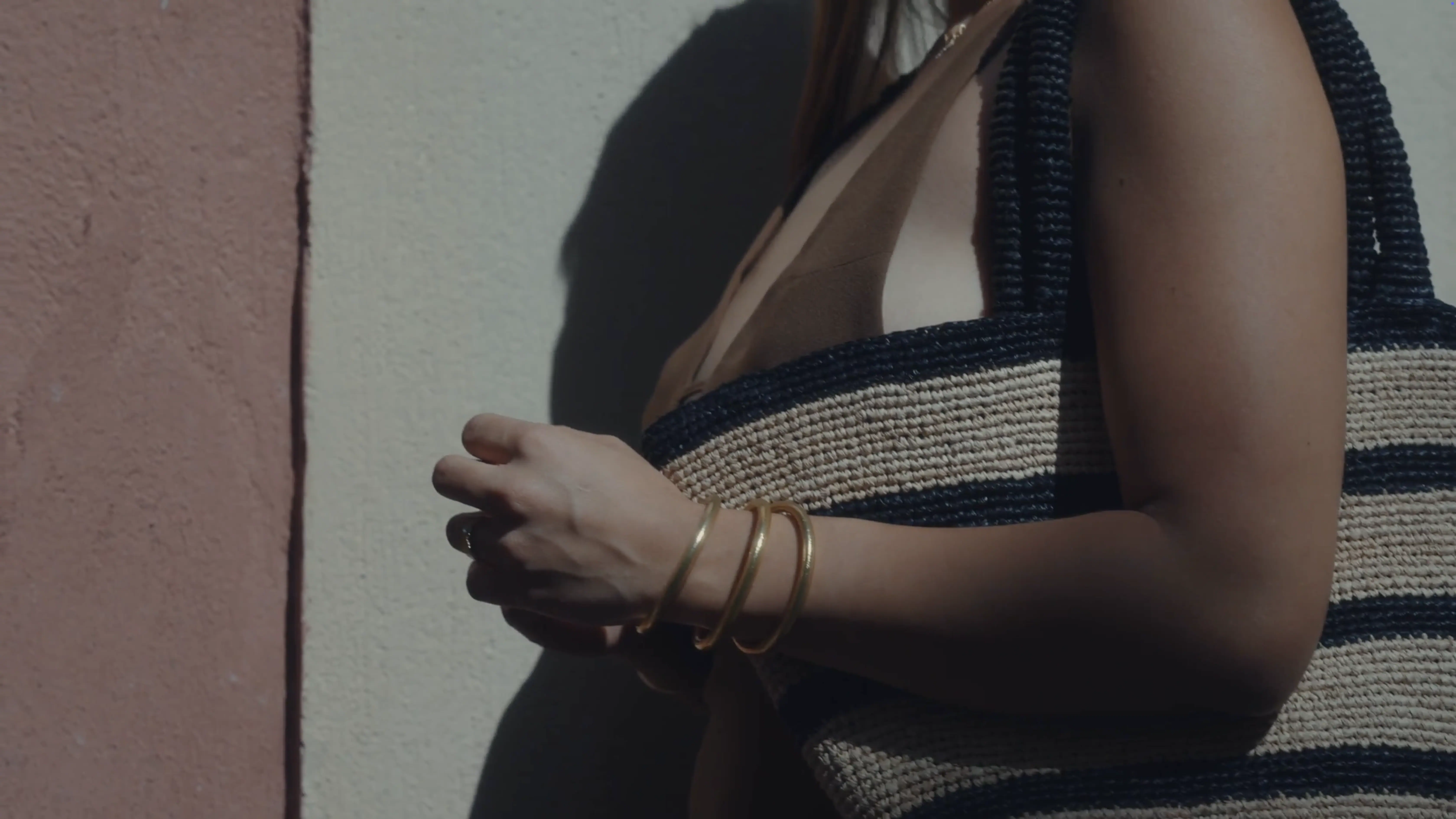 A person against a wall hanging a bag