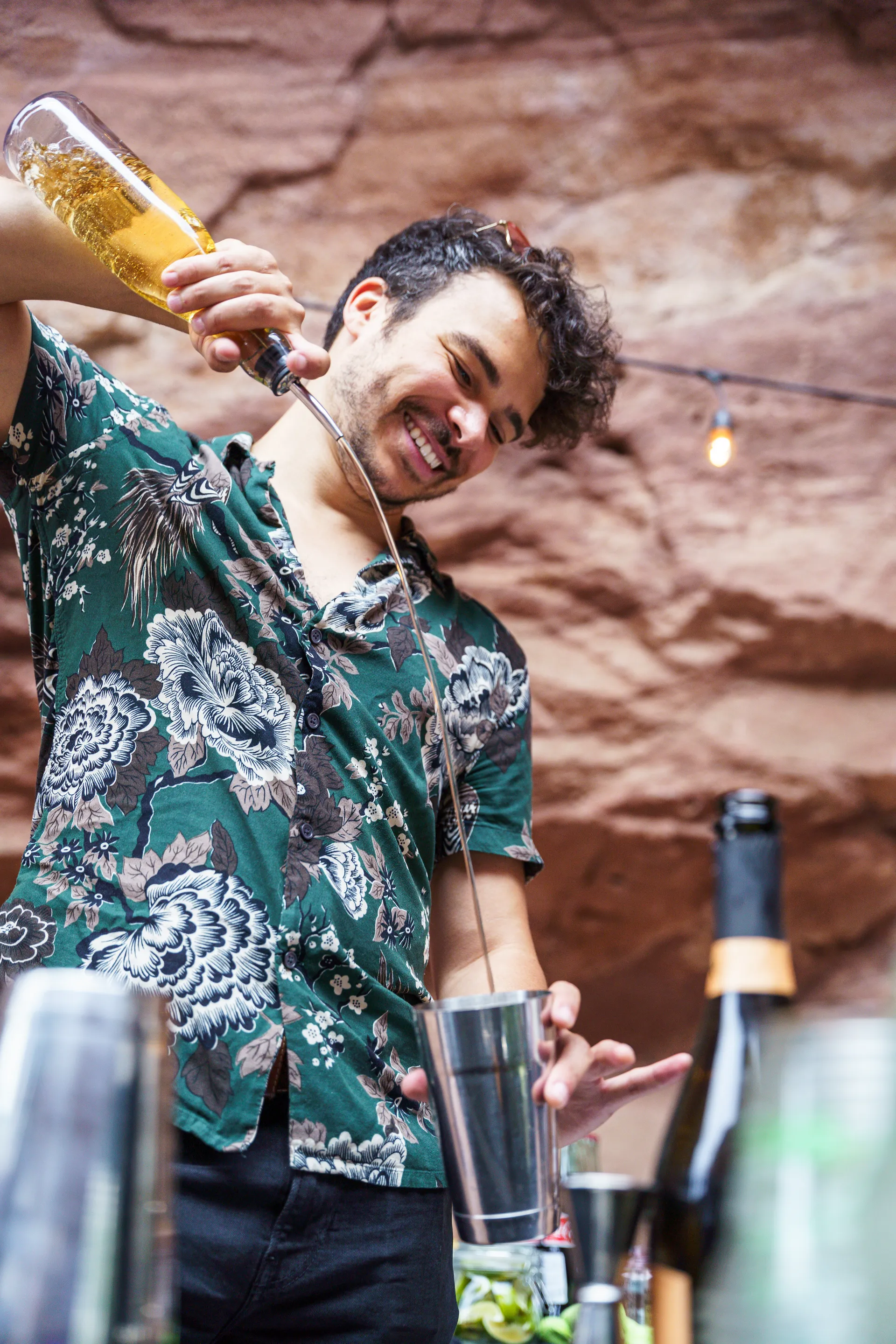 Bartender Josh Duncan pouring spirits from a bottle into a shaker