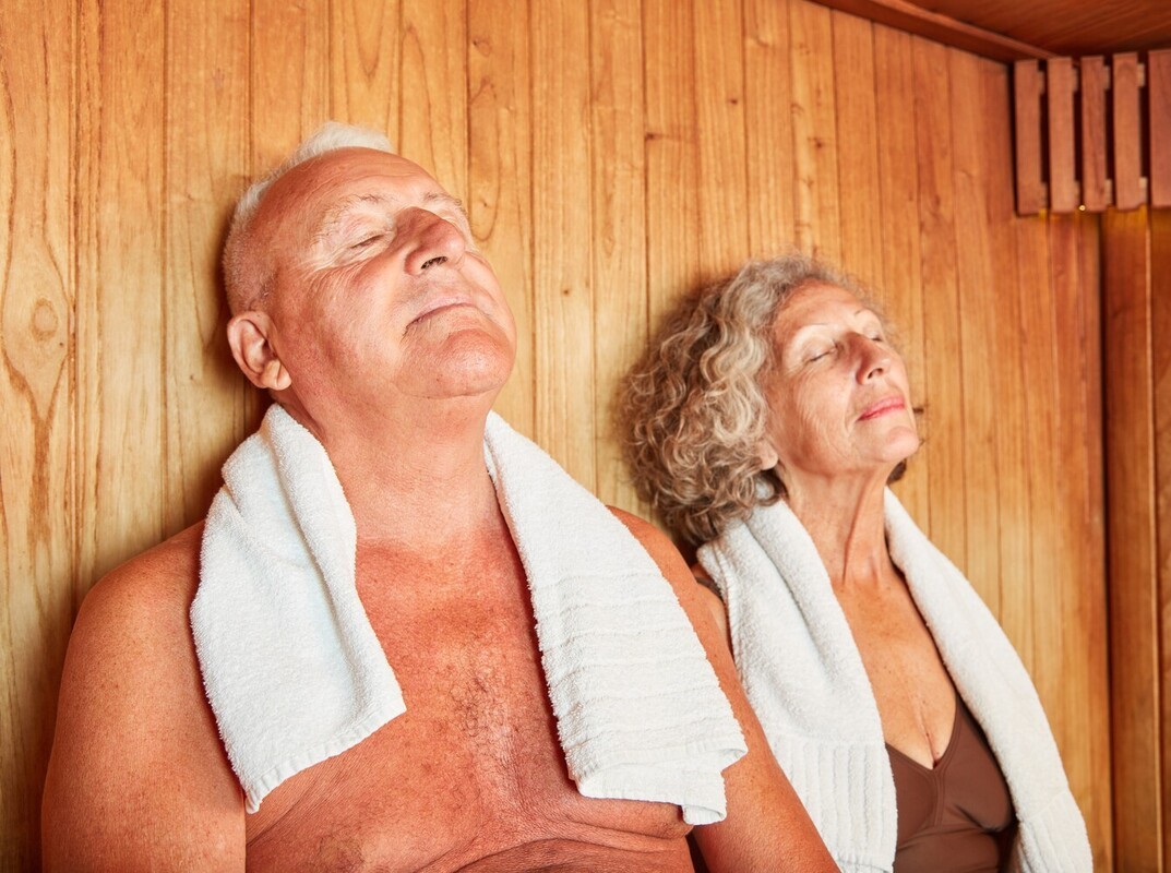 older couple enjoying a sauna after hitting the gym, showing how to use a sauna to lose weight in reality