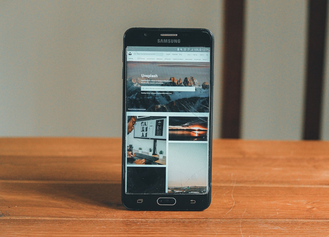 a black smartphone on a wooden surface
