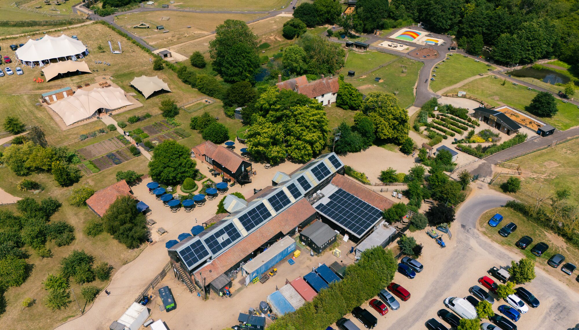 Wide aerial view of the Jimmy's Farm site, with solar panels on the main buildings