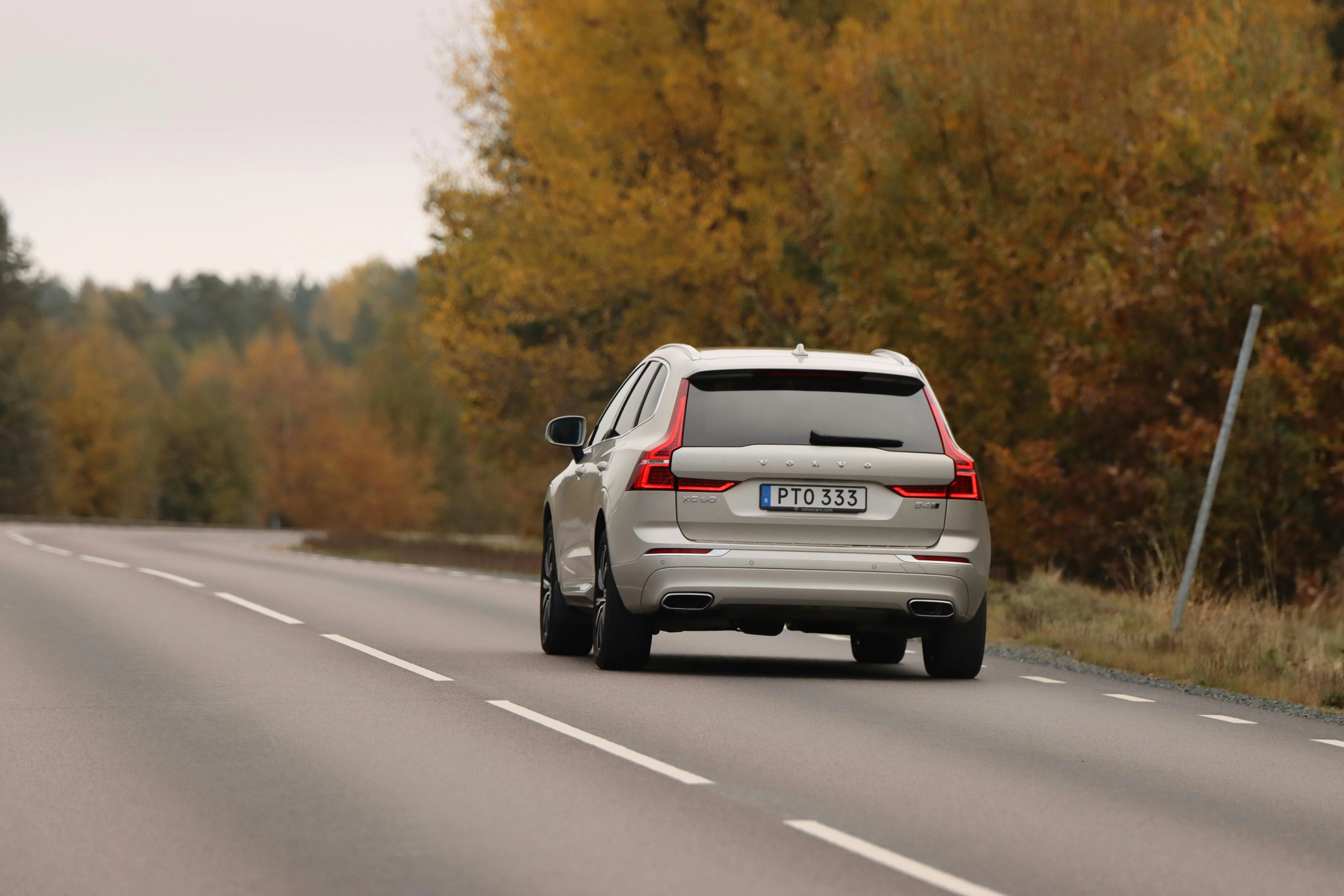 Un SUV Volvo sur une route automnale, symbole de confort, de sécurité et d’élégance suédoise.
