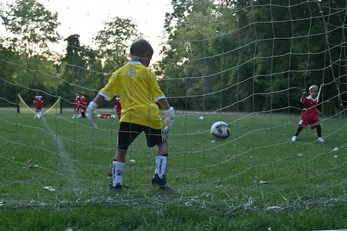 a young boy sitting on a ledge with his legs crossed