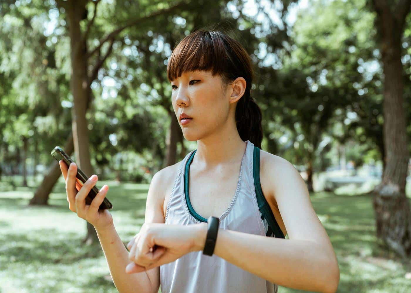 Woman with fitness werable looking at phone