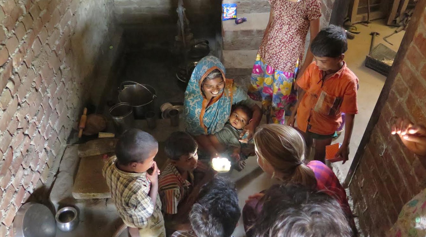 Family gathered around portable solar light.
