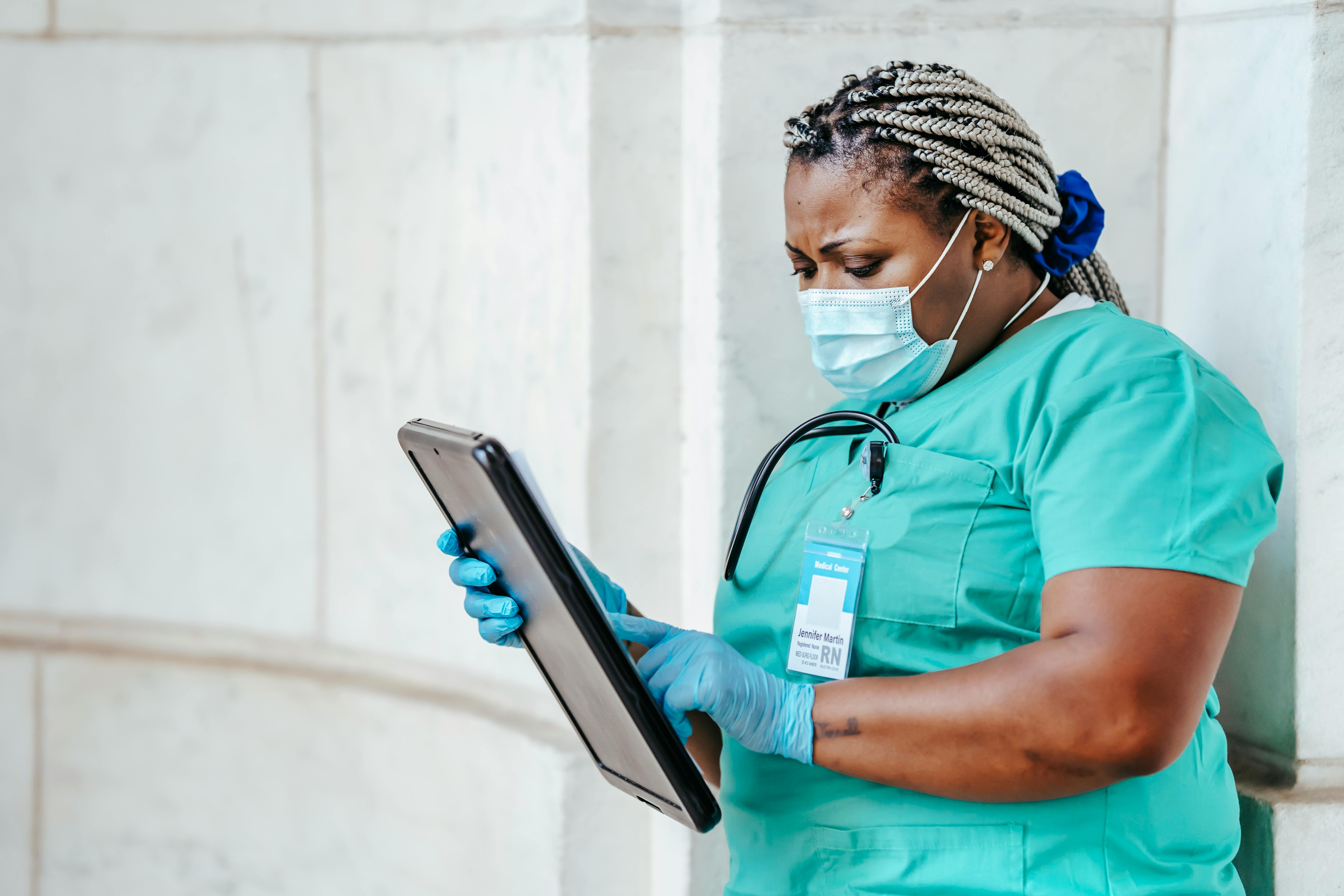 A smiling woman doctor is sitting at her desk and looking at a computer screen showing a medical screening test.