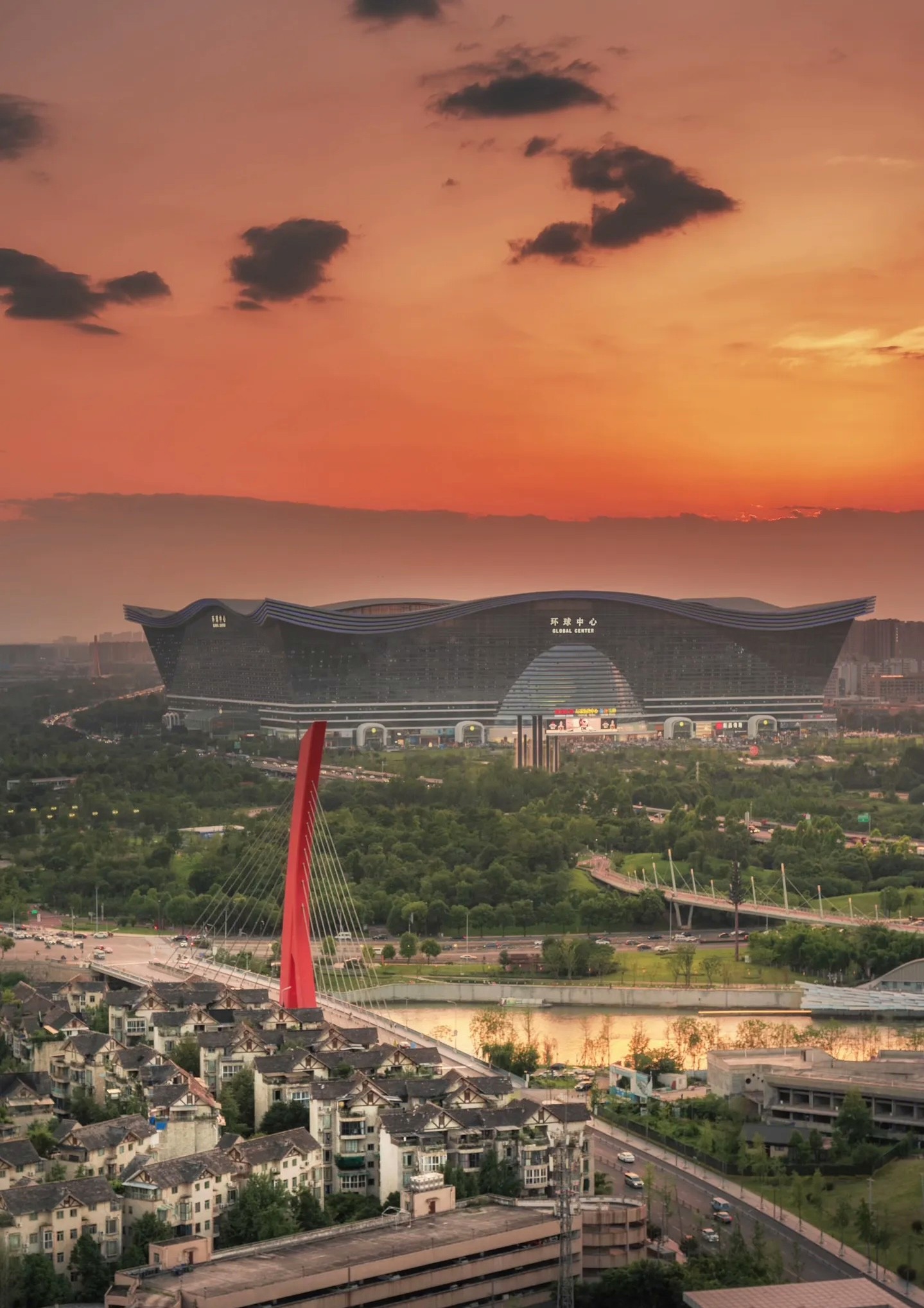 Aerial sunset shot of Chengdu Global Center alongside red cable-stayed bridge