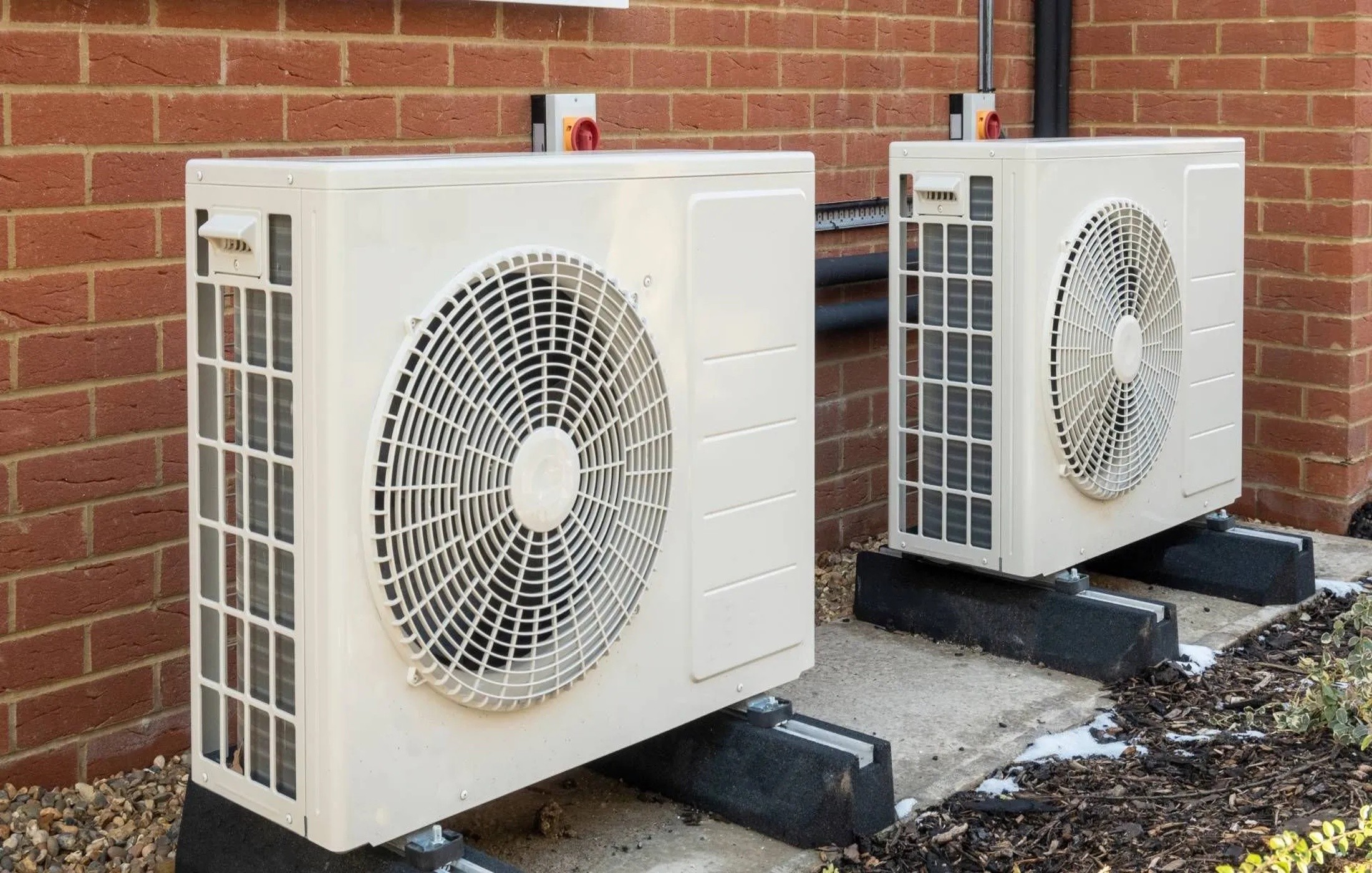 Outdoor air-source heat pump units installed beside a home for efficient heating and cooling