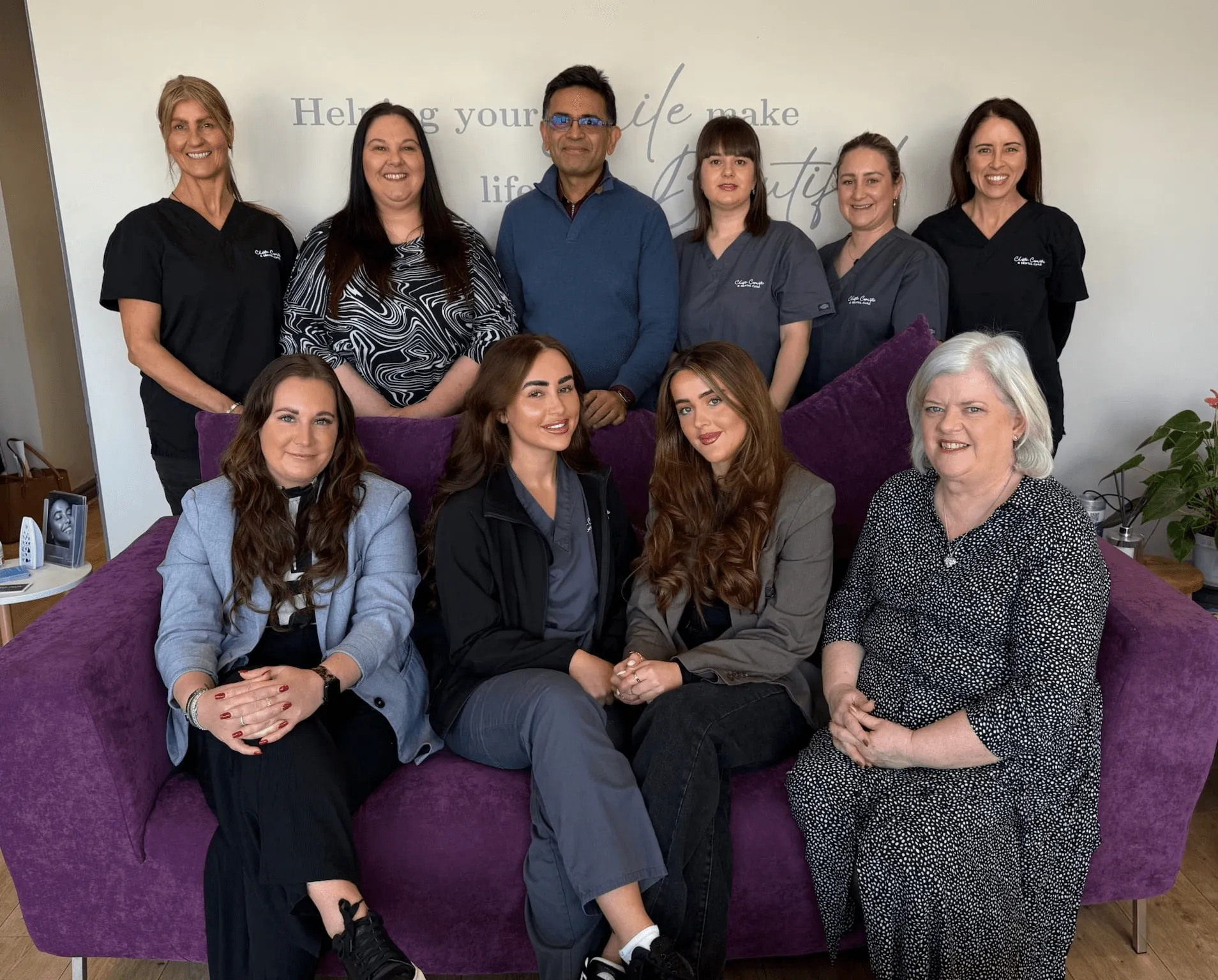 The Team of Dentist and Nurses at Chester Cosmetics & Dental Care sat on a couch and some standing behind