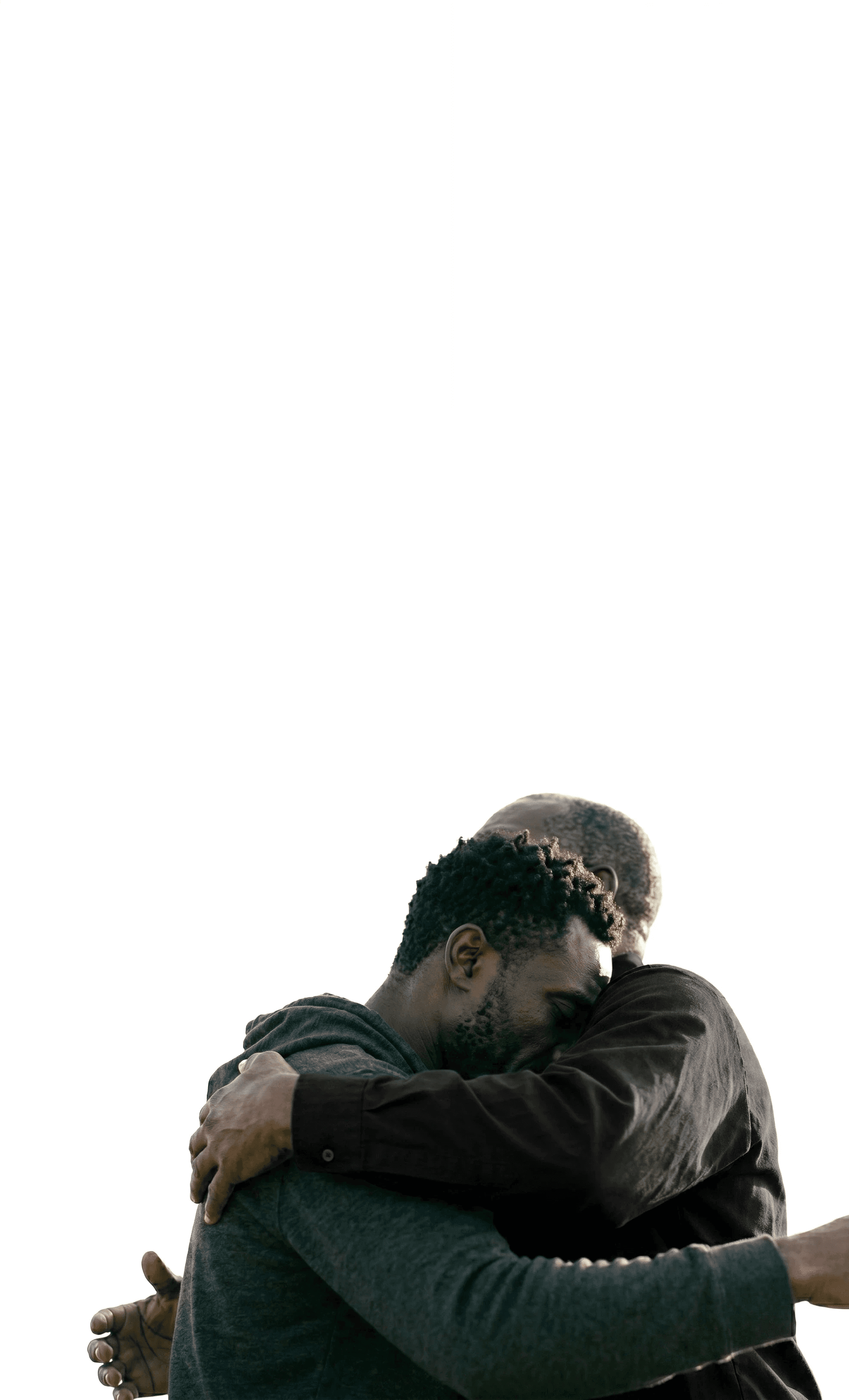 Two individuals share a heartfelt embrace against a plain white background, highlighting themes of connection, warmth, and emotional support.