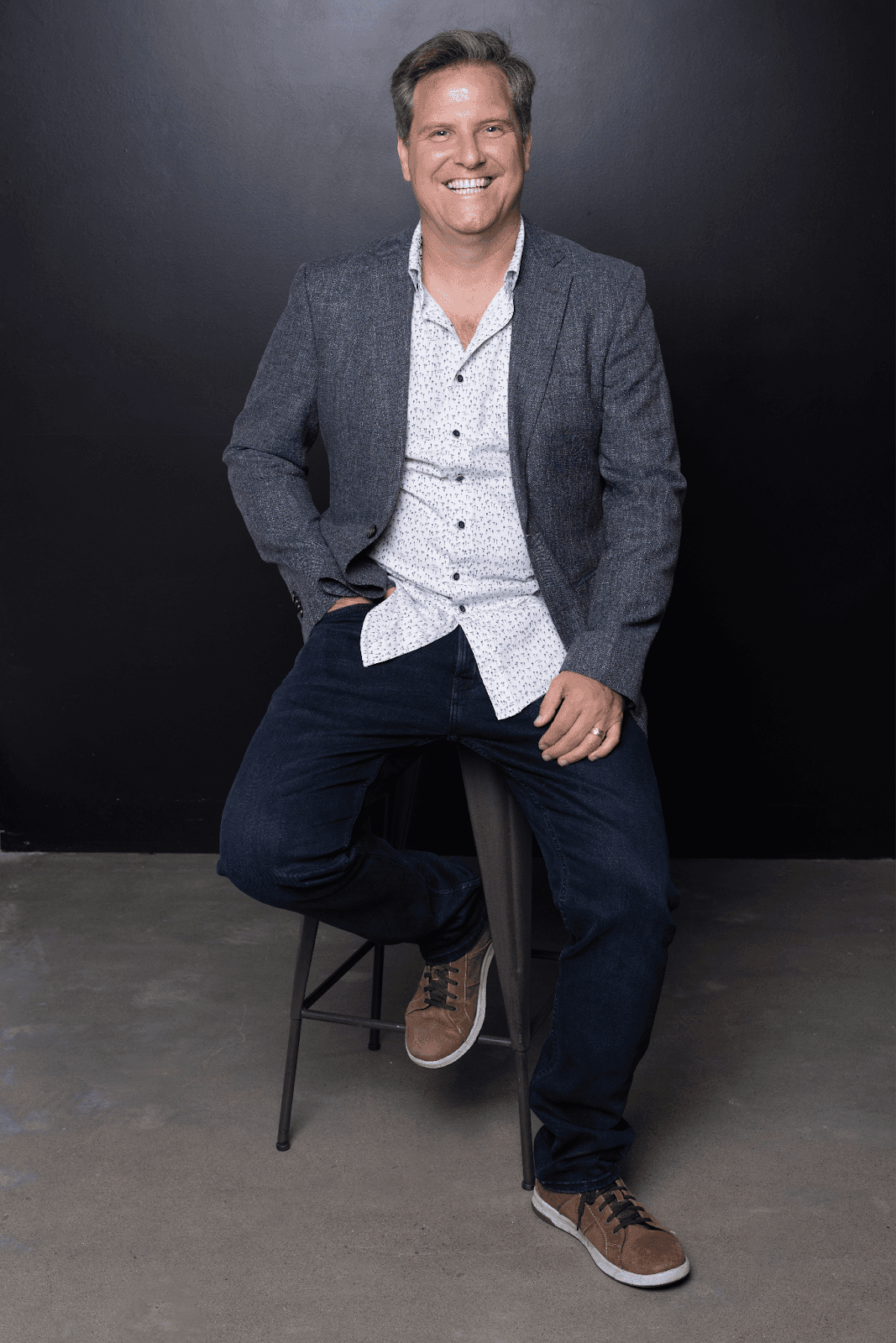 Craig Young smiling in white shirt, founder of Intrinsic Living®, redefining success for high-performing women through emotional mastery.