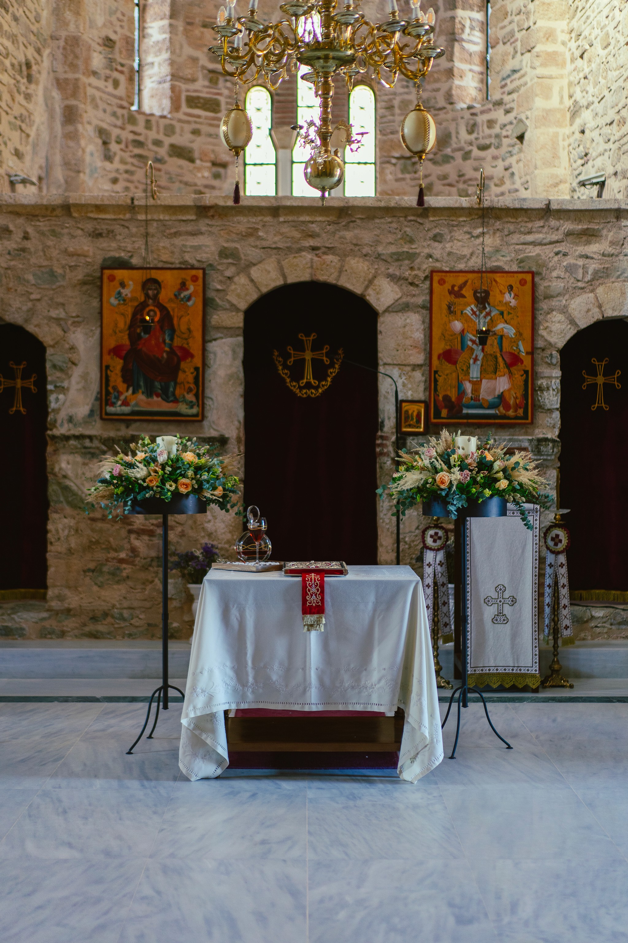 Στολισμός εσωτερικού παραδοσιακής ορθόδοξης εκκλησίας με λευκές ανθοσυνθέσεις