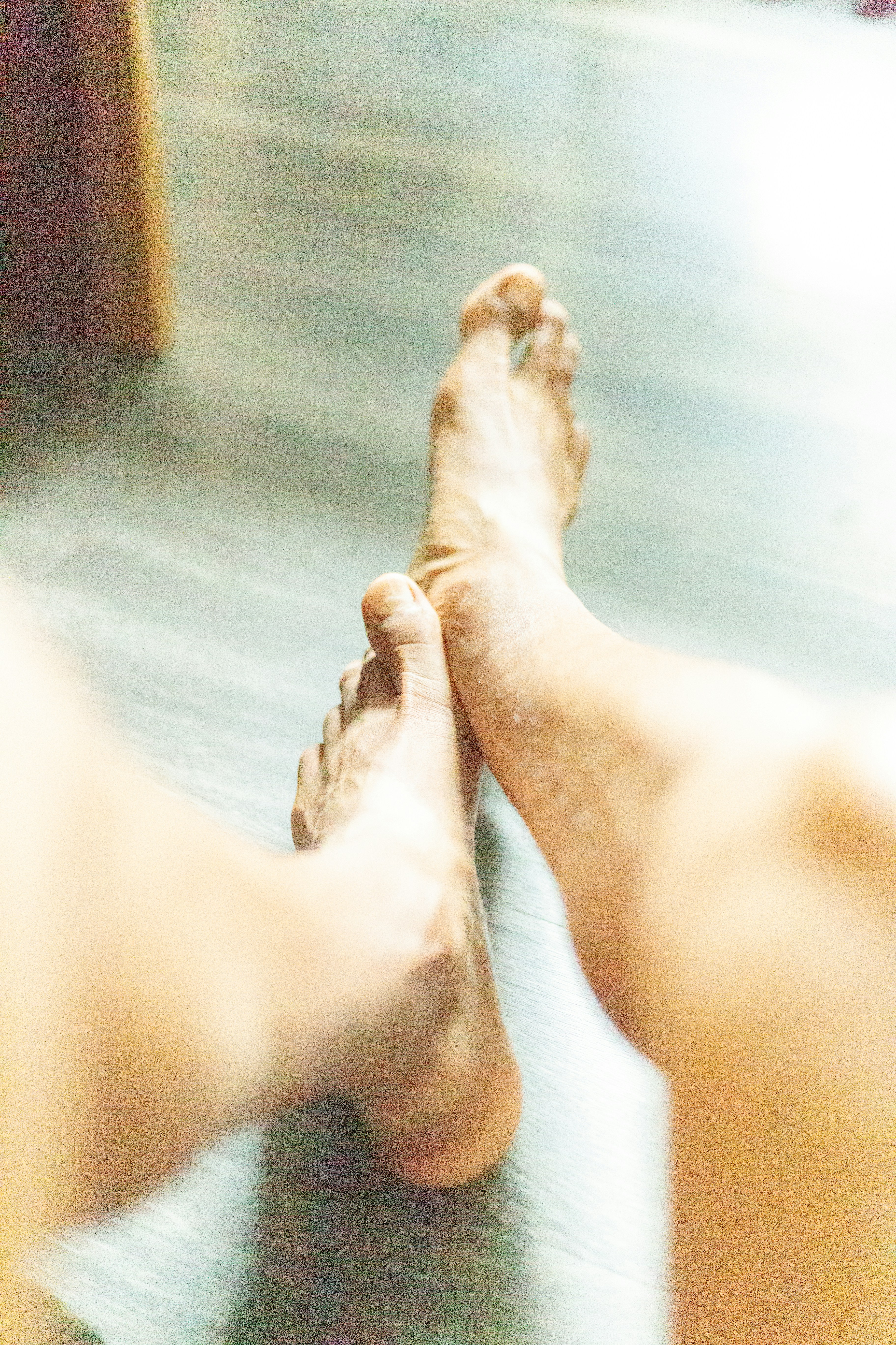 a close up of a person's bare feet on a wooden floor