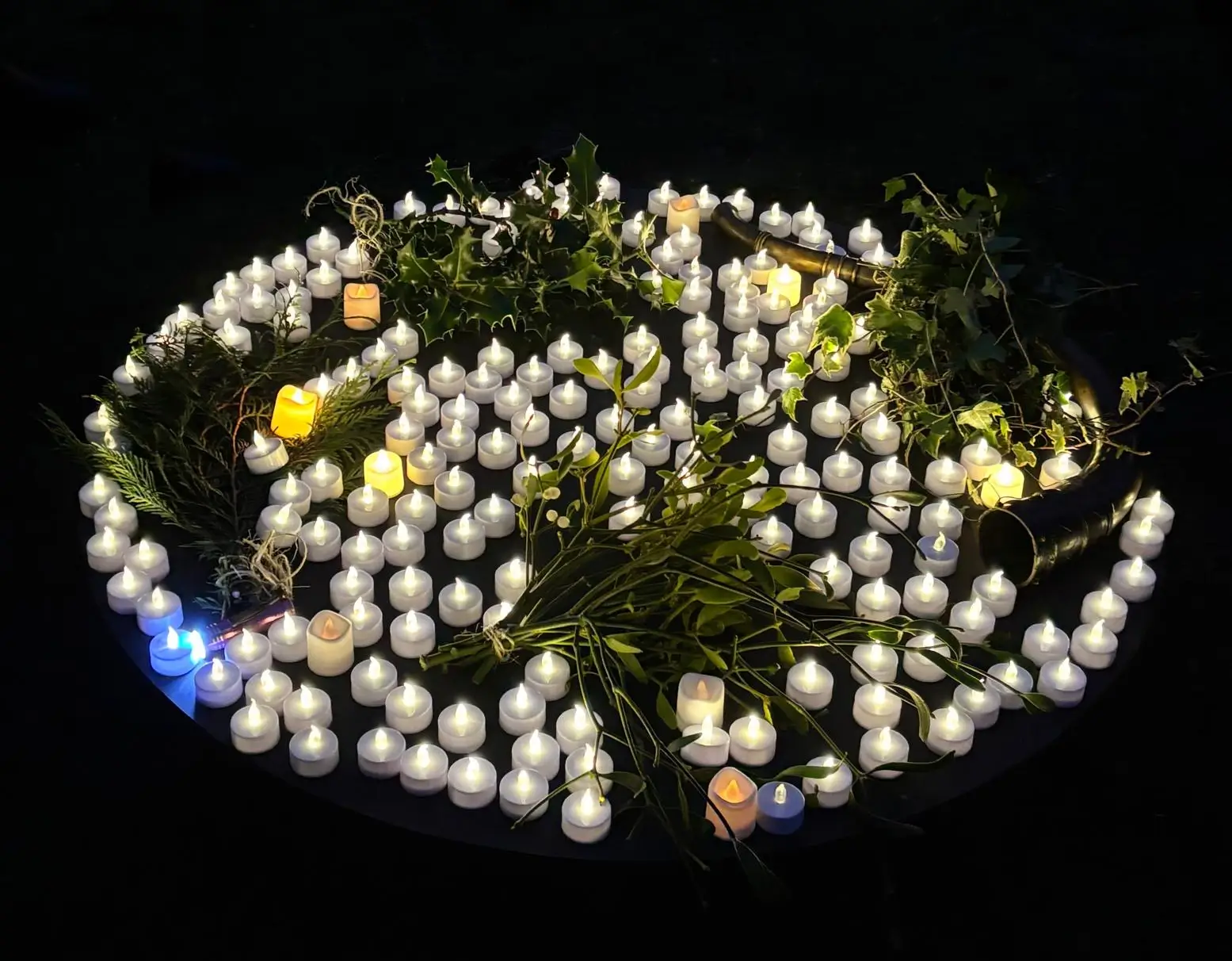 A circular arrangement of glowing lights set against a dark background, creating a festive atmosphere.
