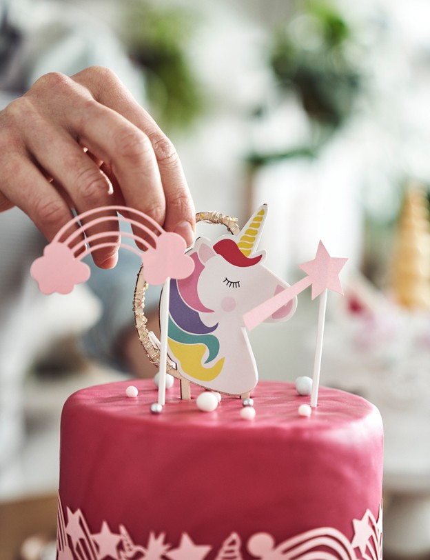 Photographie d'un gâteau d'anniversaire, avec une licorne dessus.