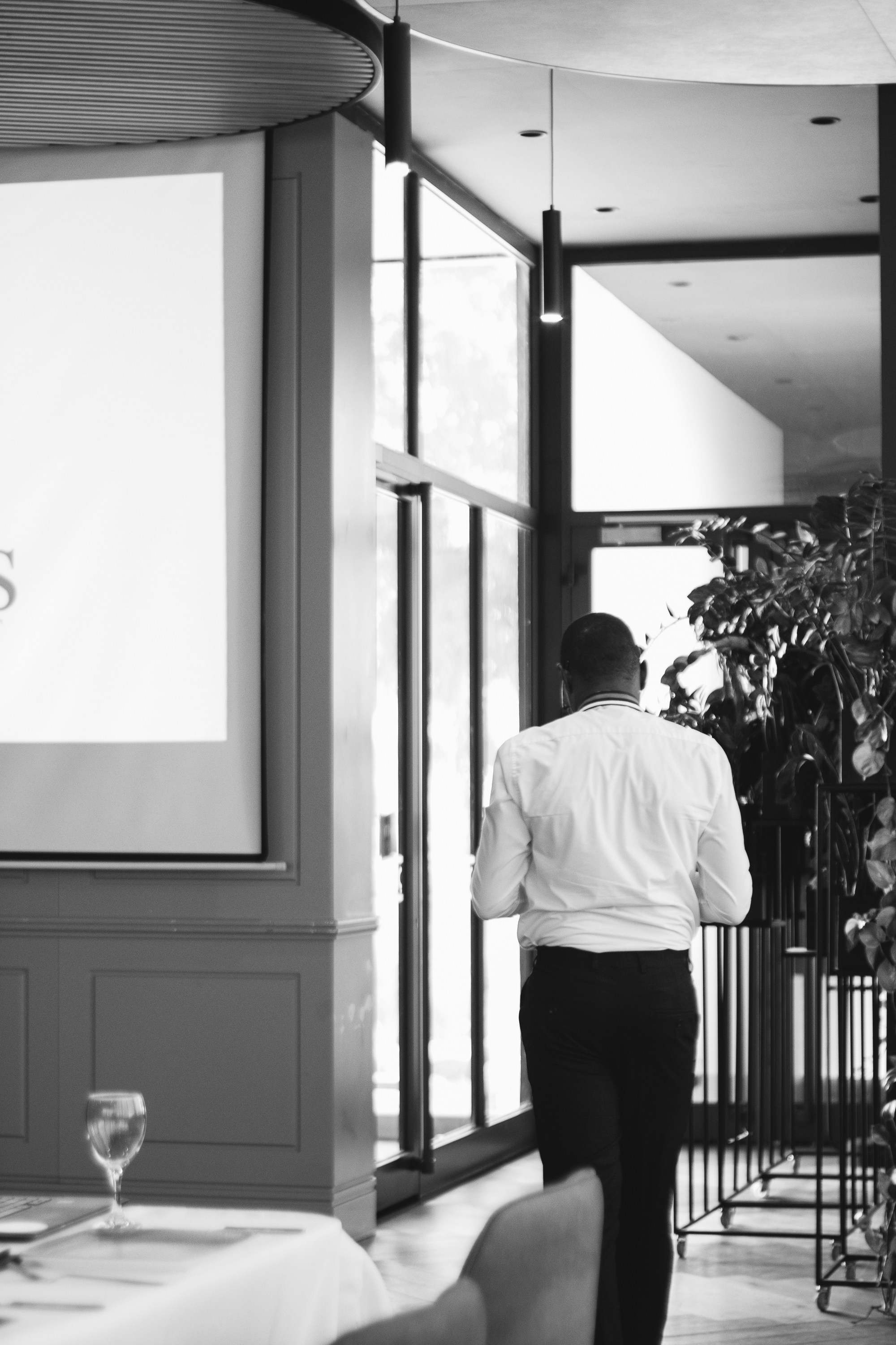 Man in white shirt walking into a room.