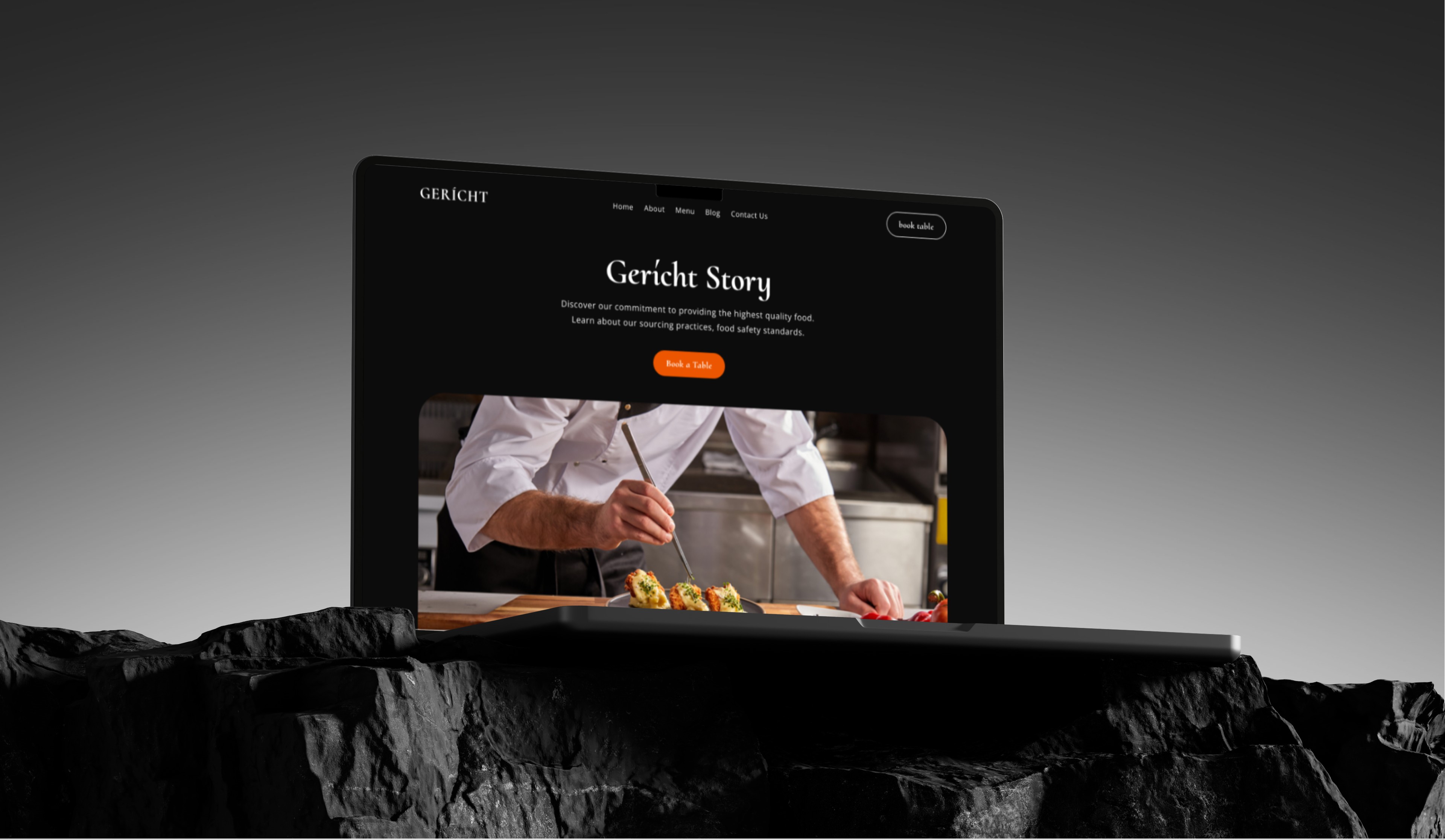 A laptop resting on a dark, textured surface, displaying the homepage of the "Gericht Website." The website features a dark color scheme, a headline, and an image of a chef working in a kitchen.