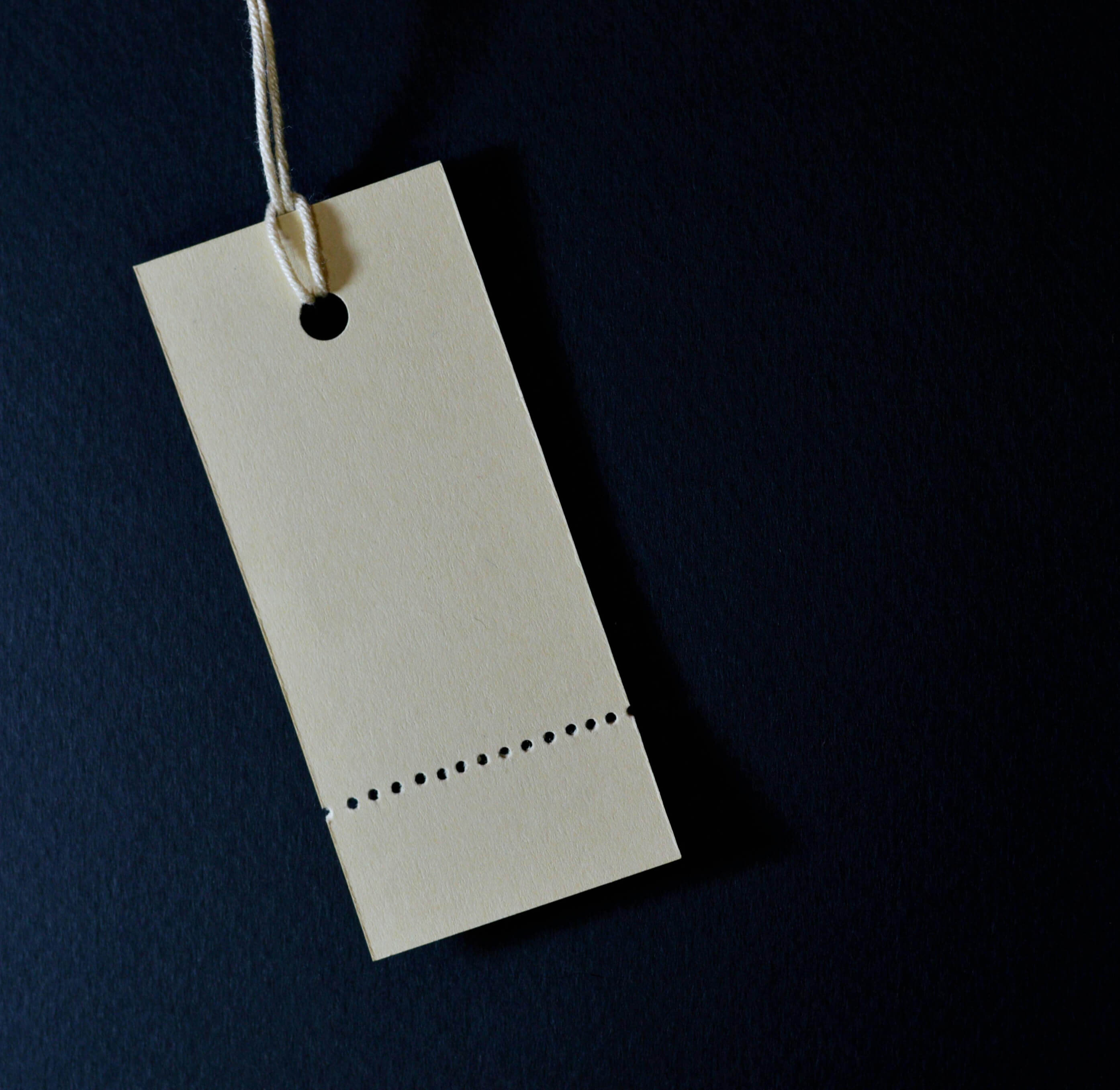 A cardboad clothing tag against a navy blue background