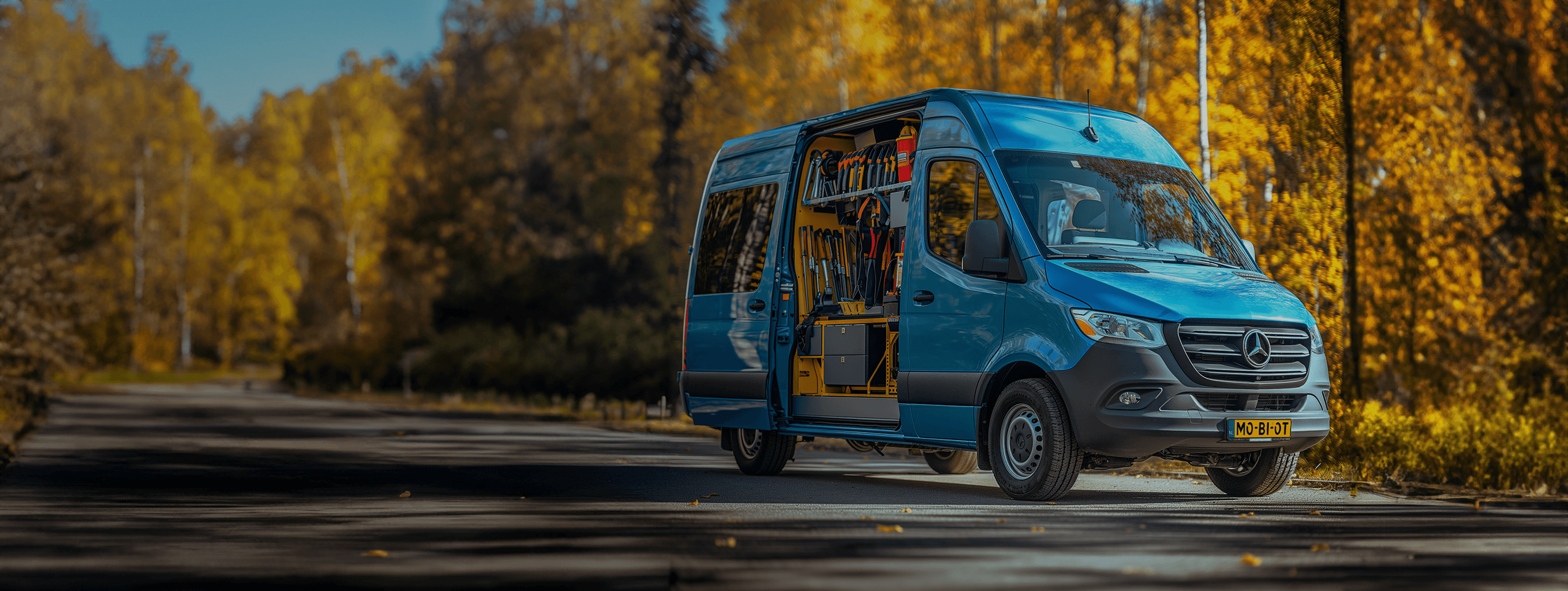 Blauwe werkbus welke half openstaat waardoor je gereedschap ziet zitten. De bus heeft een kenteken met de letters MobioT erop