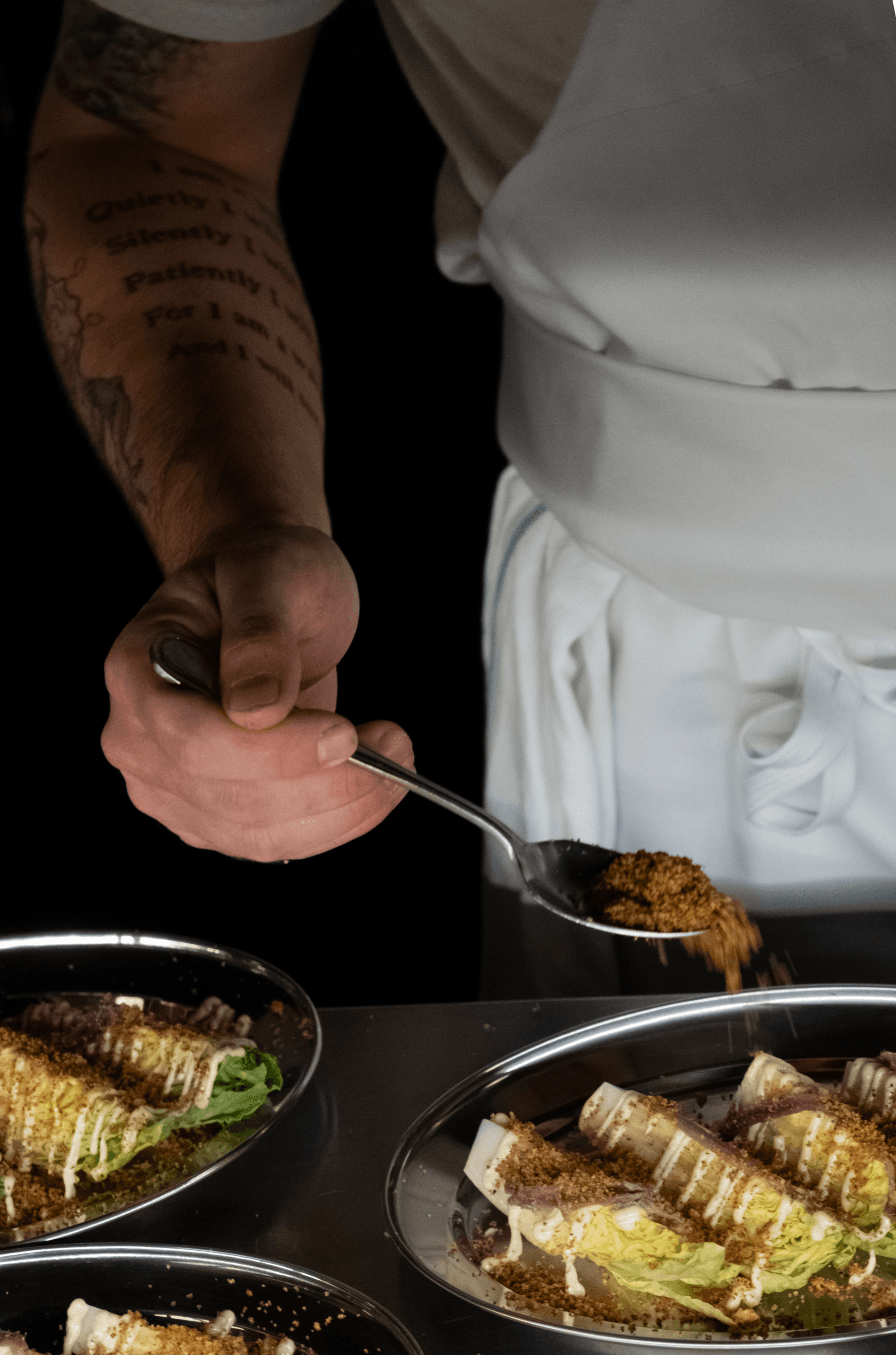 Un cuisinier du Saison prépare les entrées de salades césar.